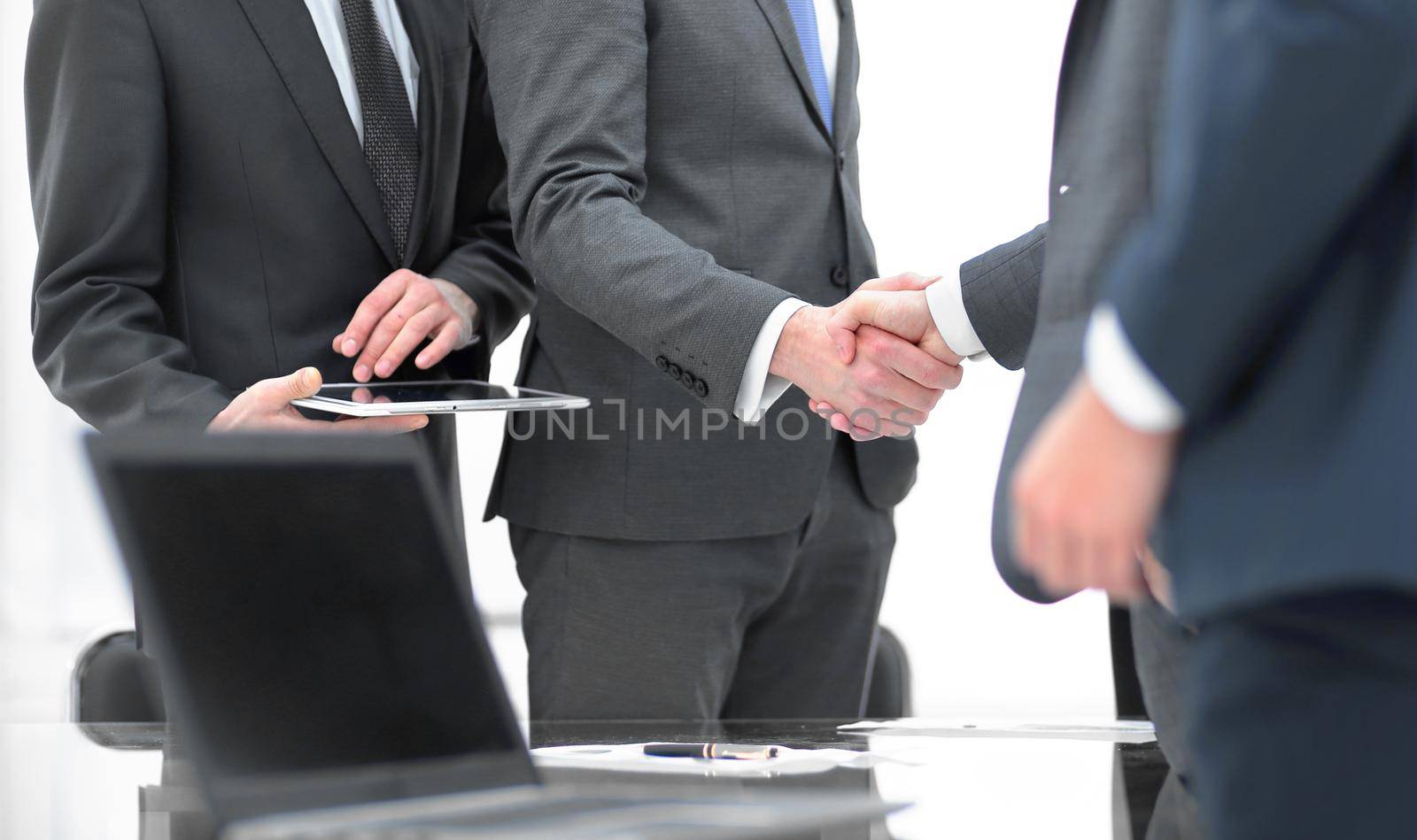 Business partners handshaking with their colleagues. by asdf