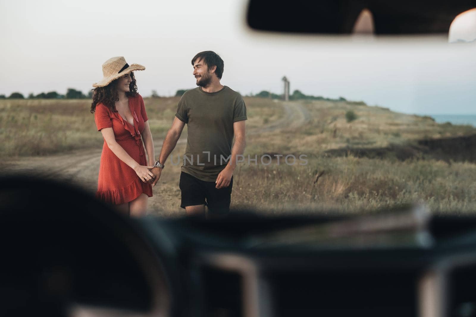 View Through Front Window of Car, Young Couple Man and Woman Having Fun Time Together Outdoors Near Sea
