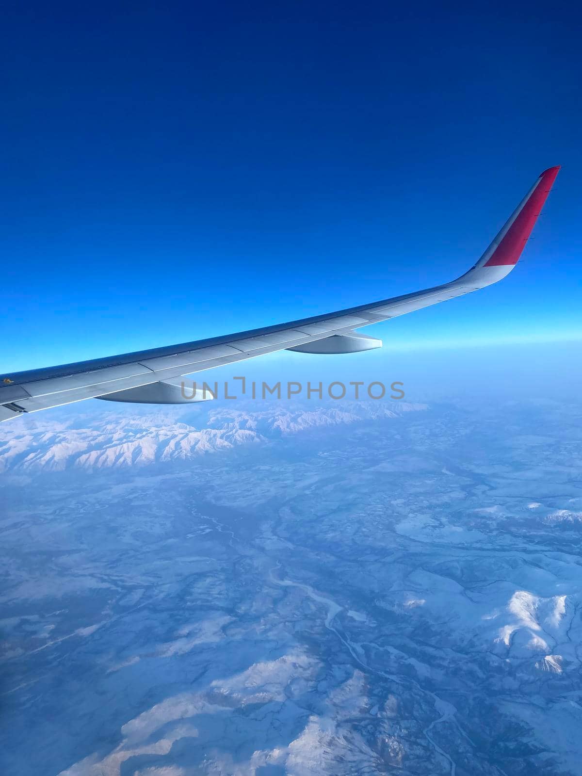 Airplane wing against the background of high mountains - Photo