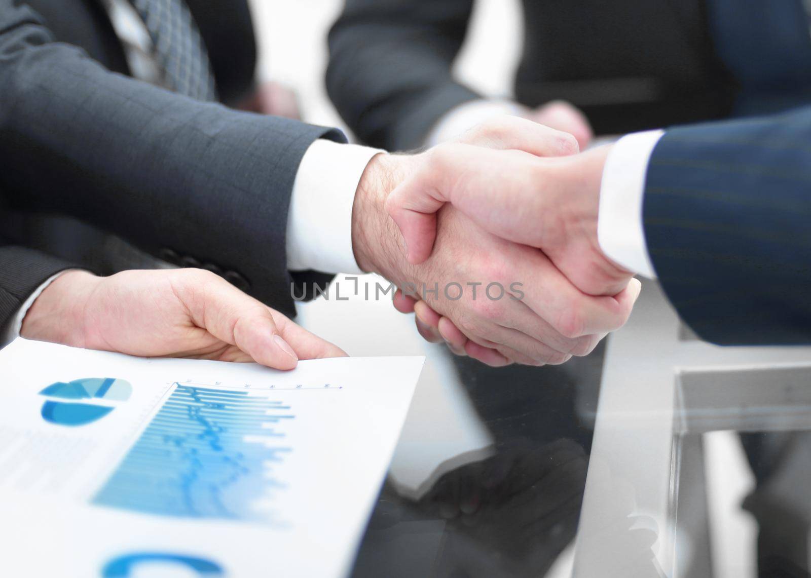 Businessmen handshaking after signing contract .