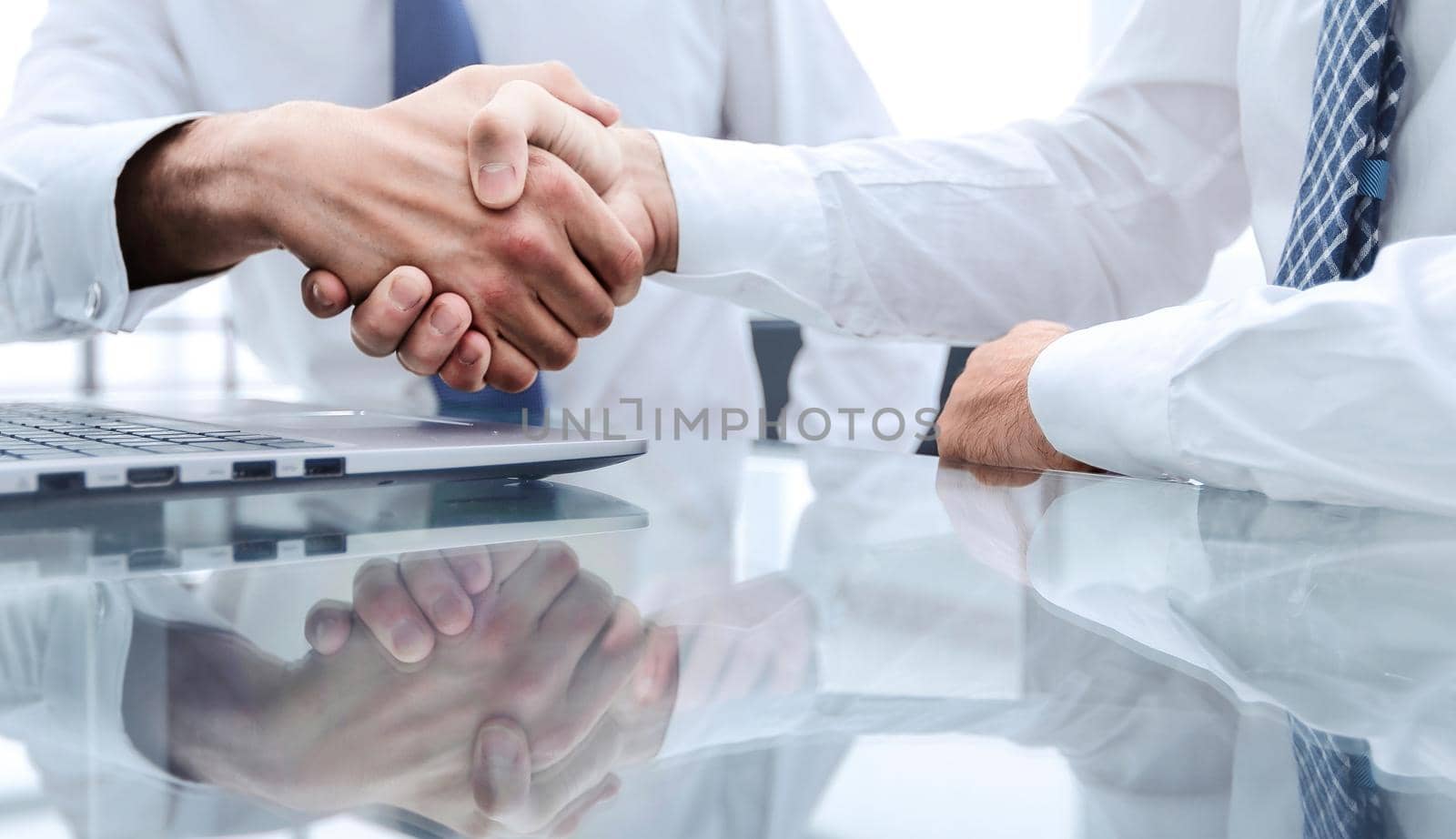 close up.colleagues shaking hands over a Desk .photo with copy space