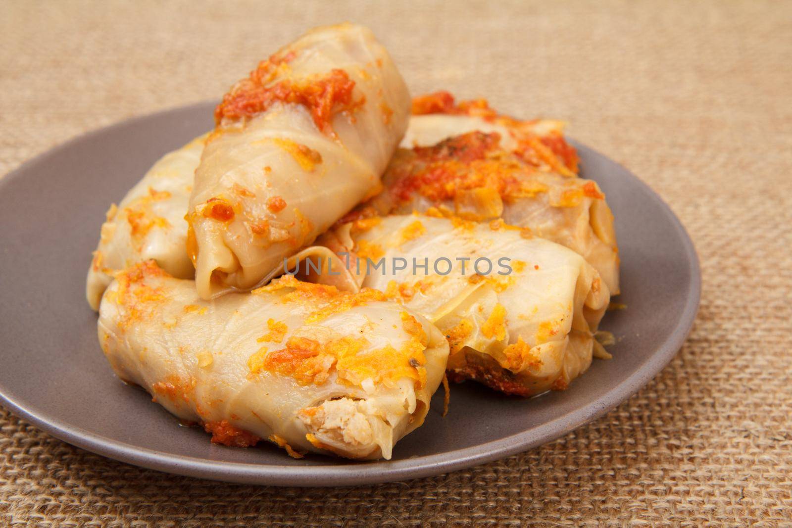 Delicious homemade cabbage rolls stuffed with rice and meat in plate on sackcloth