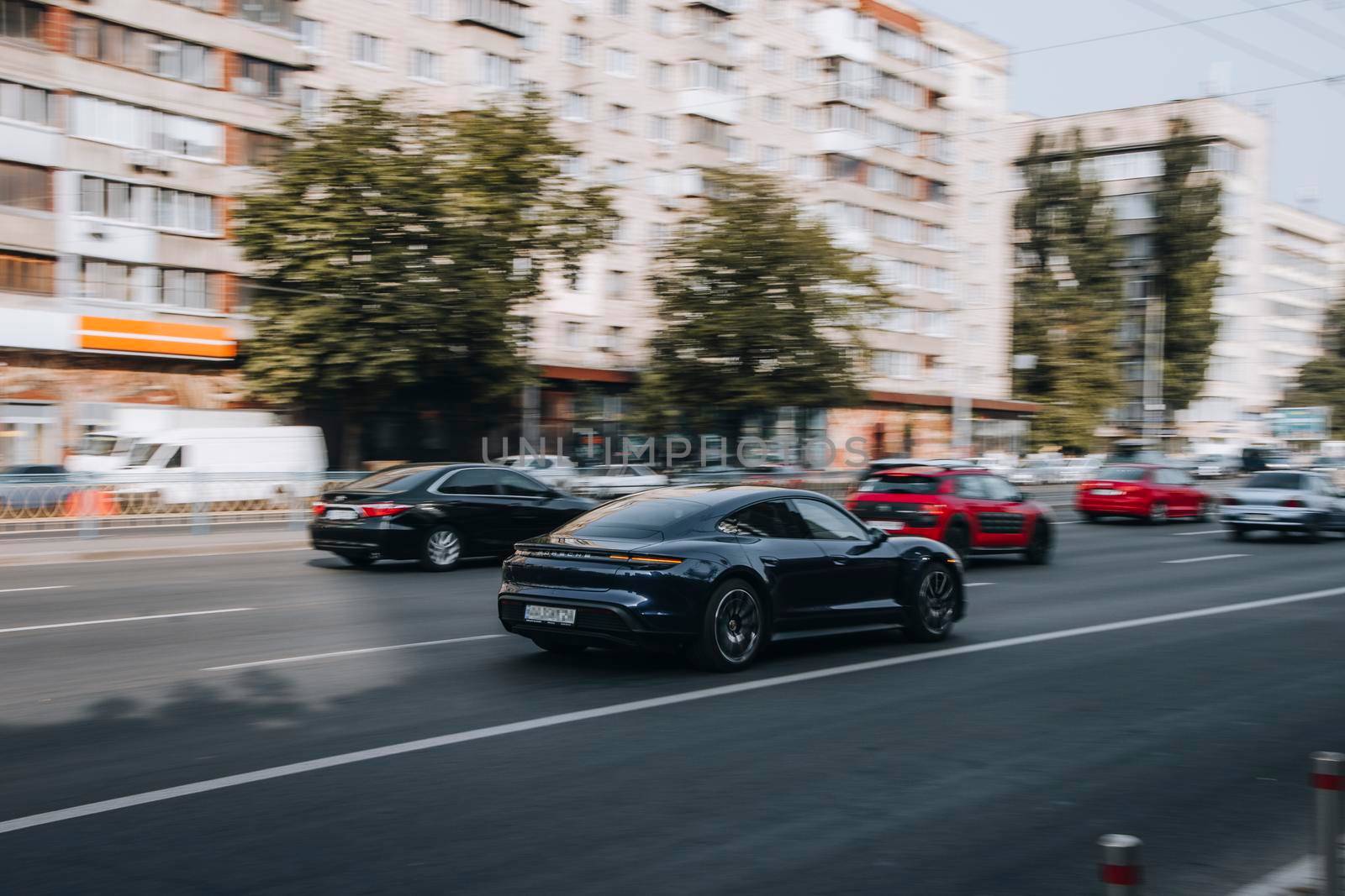Ukraine, Kyiv - 16 July 2021: Black Porsche car moving on the street. Editorial by Yuriy_Vlasenko