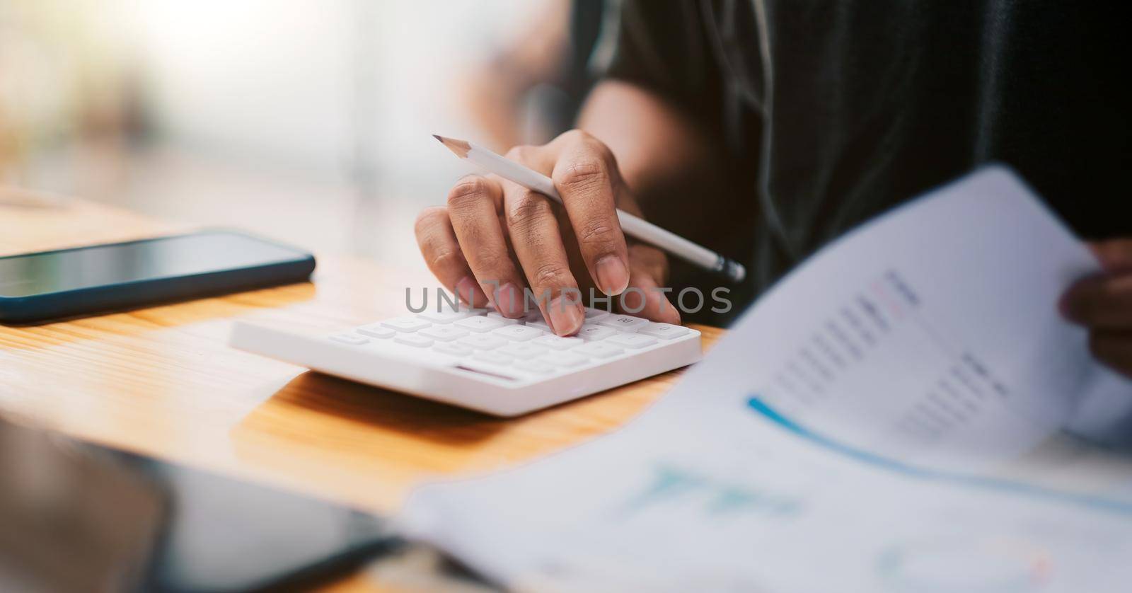 Close up hand of accountant working with computer and calculator for business and financial expense. by nateemee