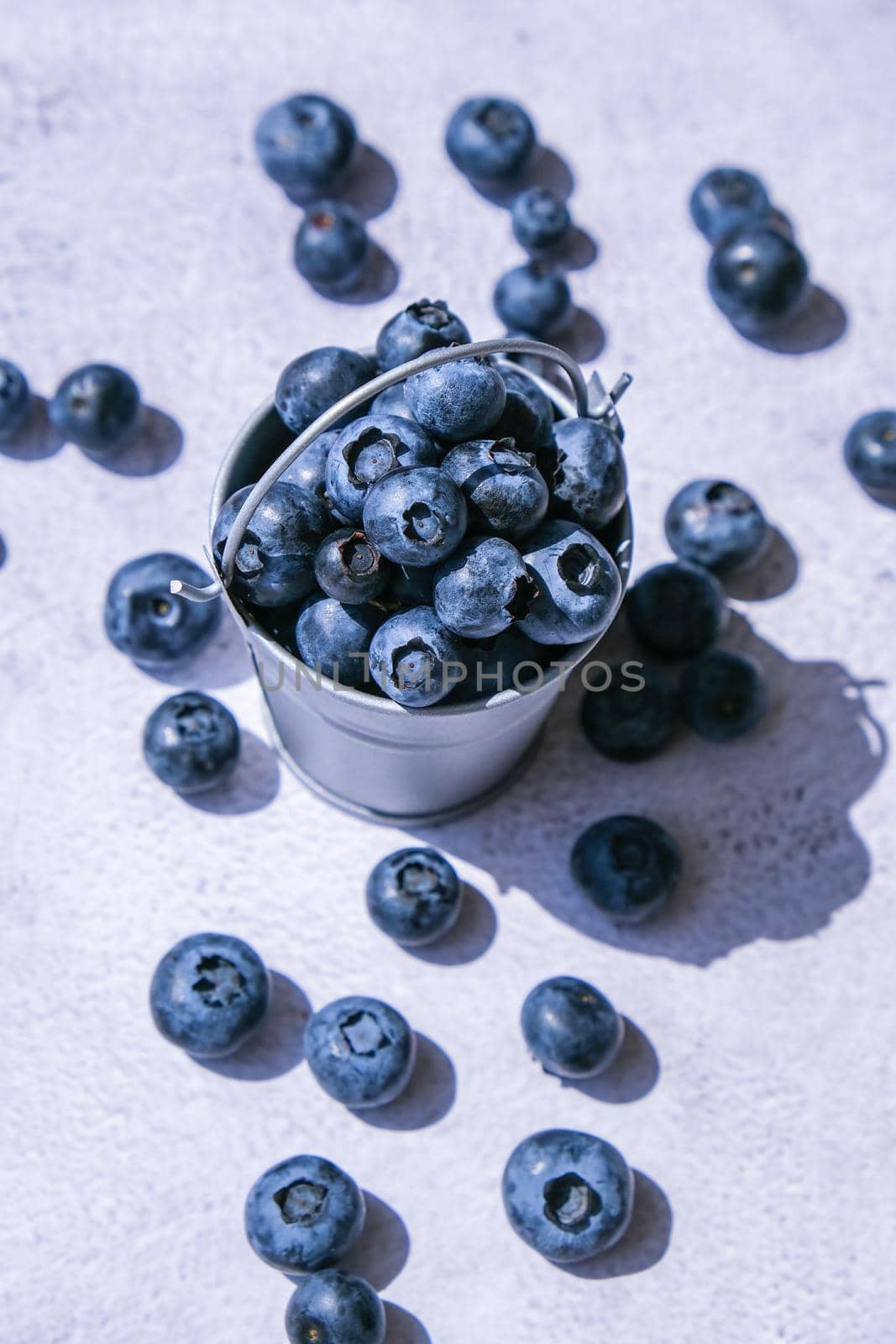 Blueberries in a small Bucket on concrete background. Healthy organic seasonal fruit background. Organic food. Healthy summer snack. Copy space Superfood. Good vision. Keep eyes healthy