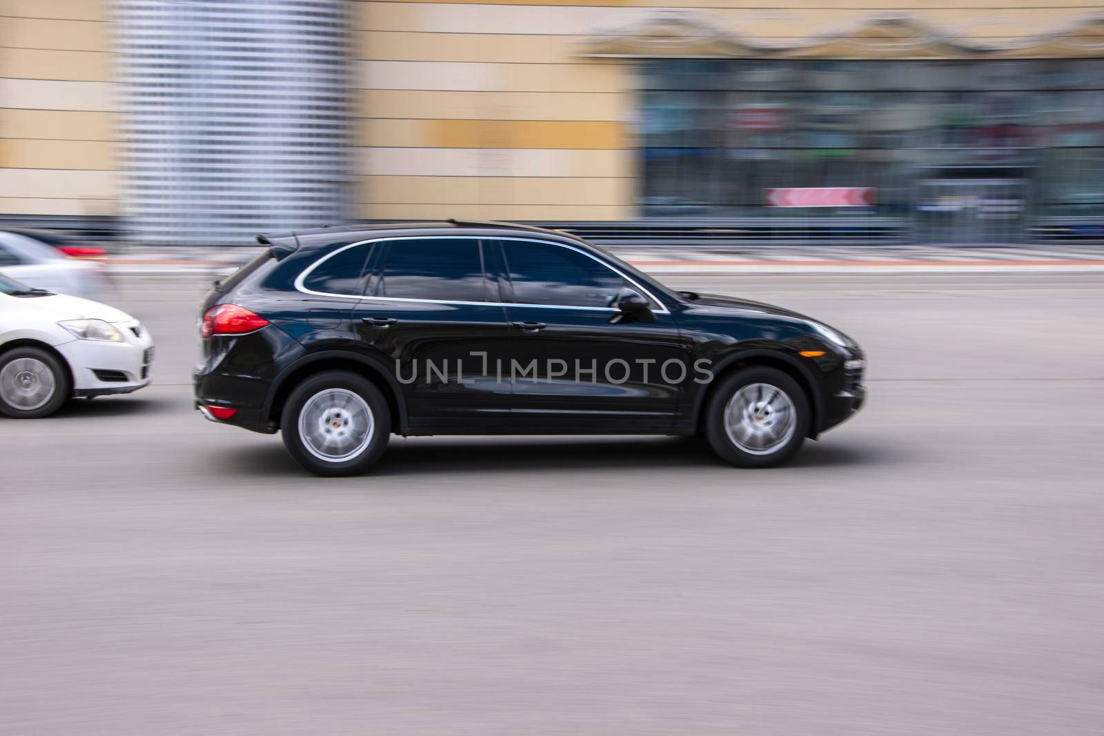 Ukraine, Kyiv - 26 April 2021: Black Porsche Cayenne car moving on the street. Editorial