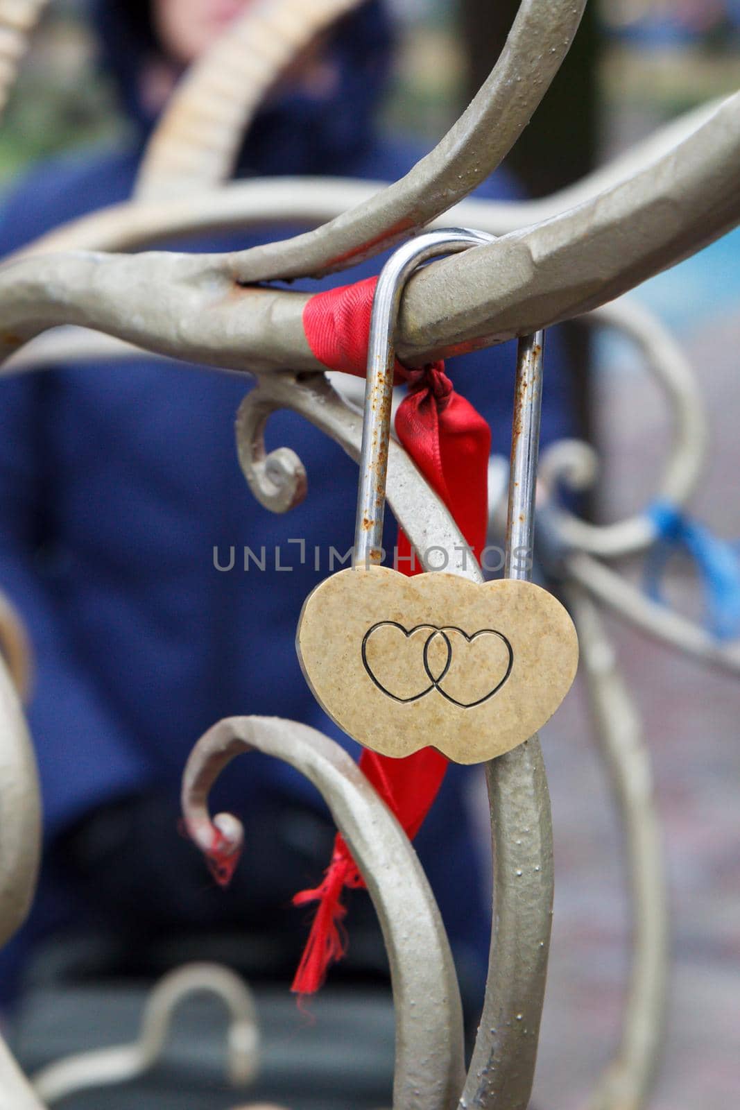 Padlock with engraving of two hearts on metal tree. Selective focus on padlock