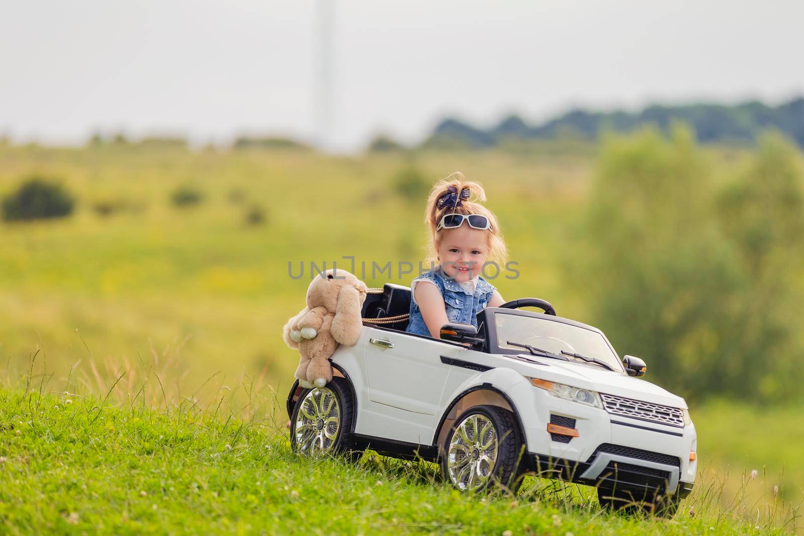 girl riding a white car on the lawn