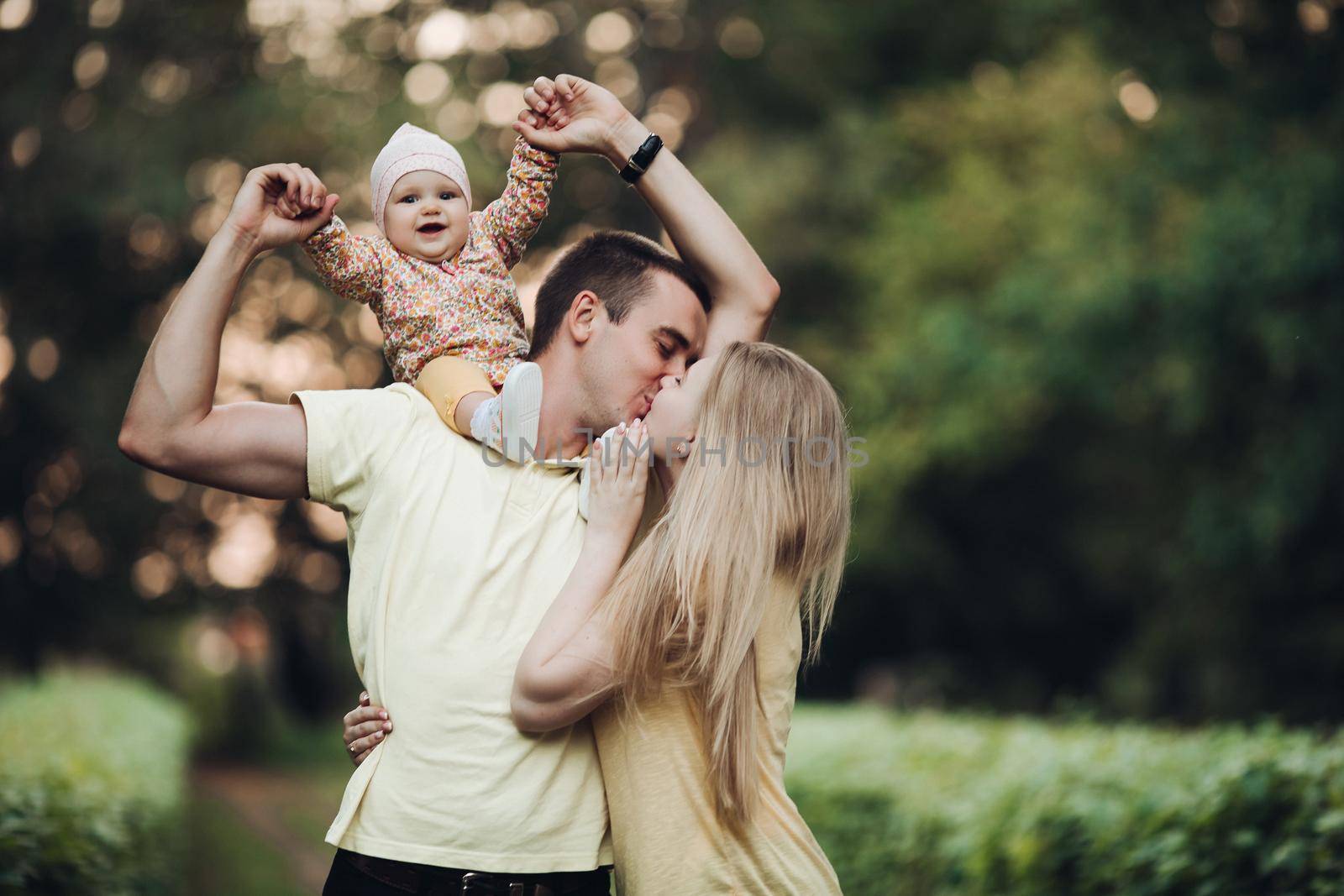 Portrait of lovely young family sitting together outside. by StudioLucky