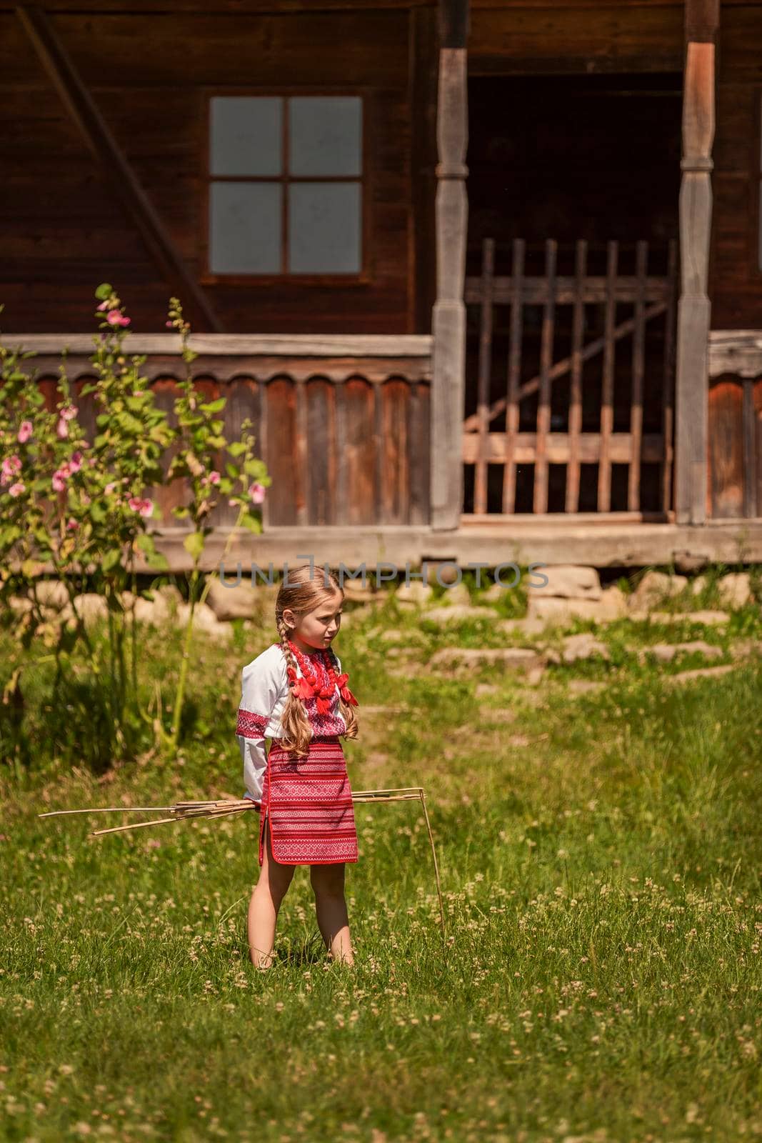 child in a traditional Ukrainian costume is playing in the yard