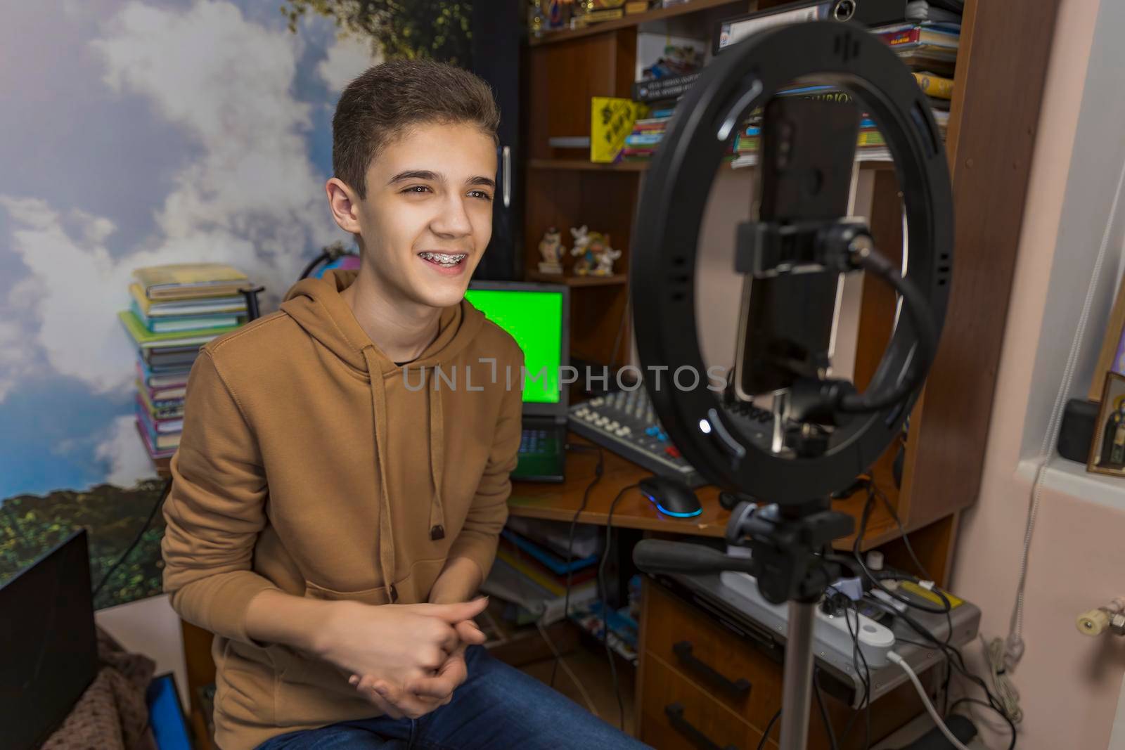 teenager is engaged in blogging sitting at a table in his room