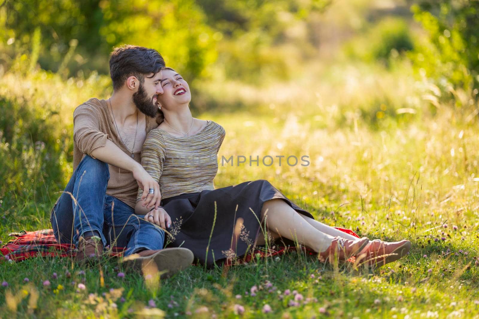 young couple sitting in summer garden