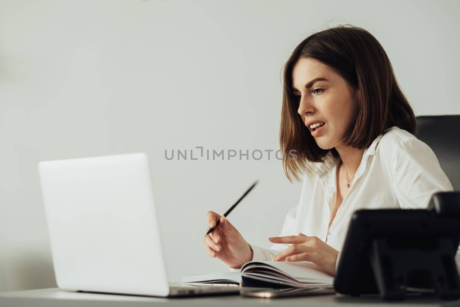 Confident Young Woman Working at Office by Laptop, Female Manager Writing Notebook at Workplace