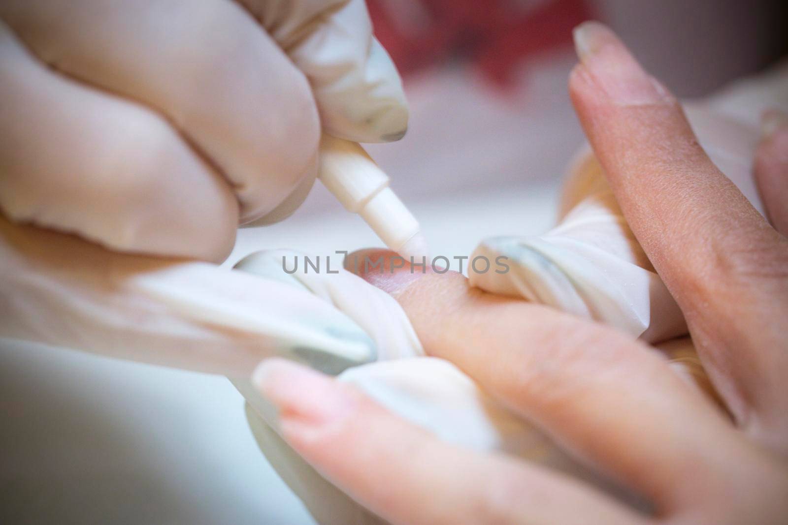 Nail beautician at work while performing the decoration and maintenance of a client's nails