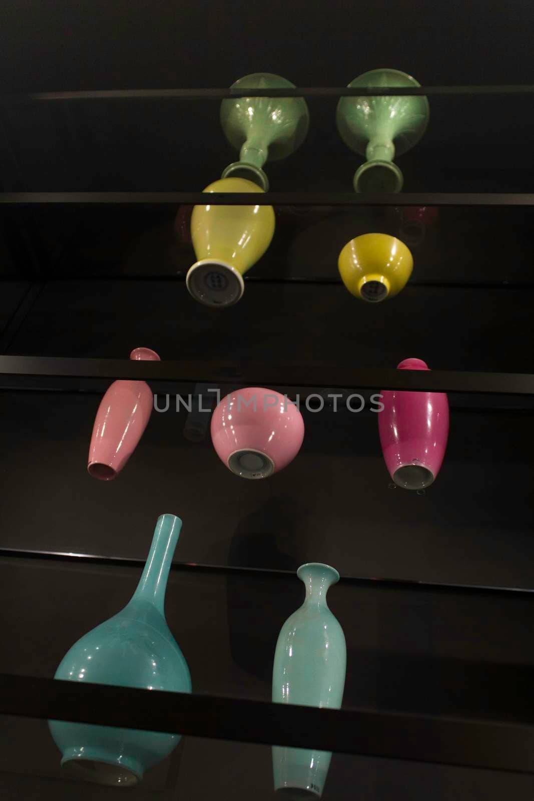 Antique colored vases placed on top of the glass shelves