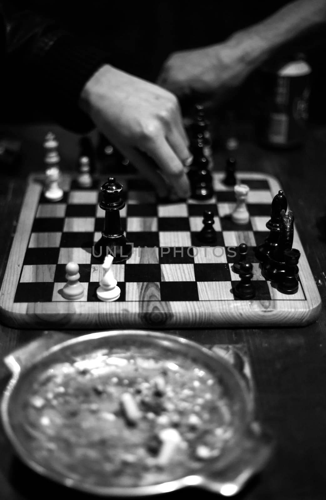 Chess game between two people you see an ashtray in the foreground