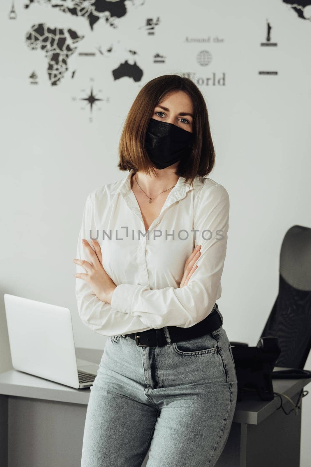 Young Caucasian Woman Wearing Protection Mask Standing in Office with Holding Arms