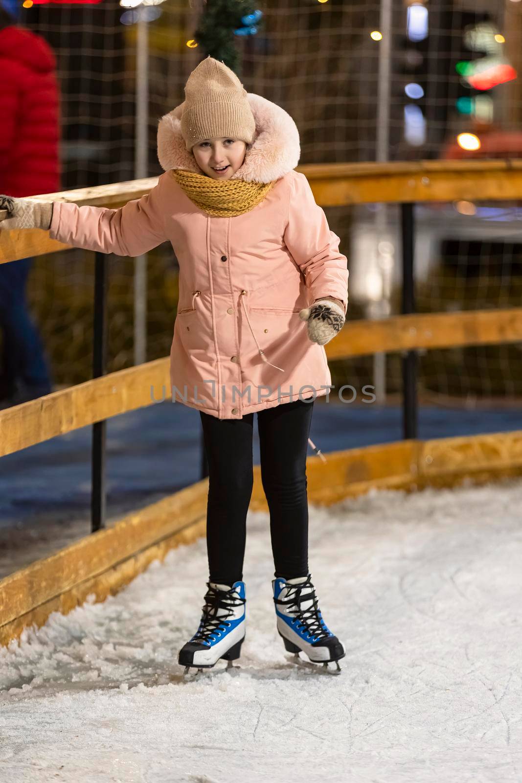 girl tries to skate on the ice rink