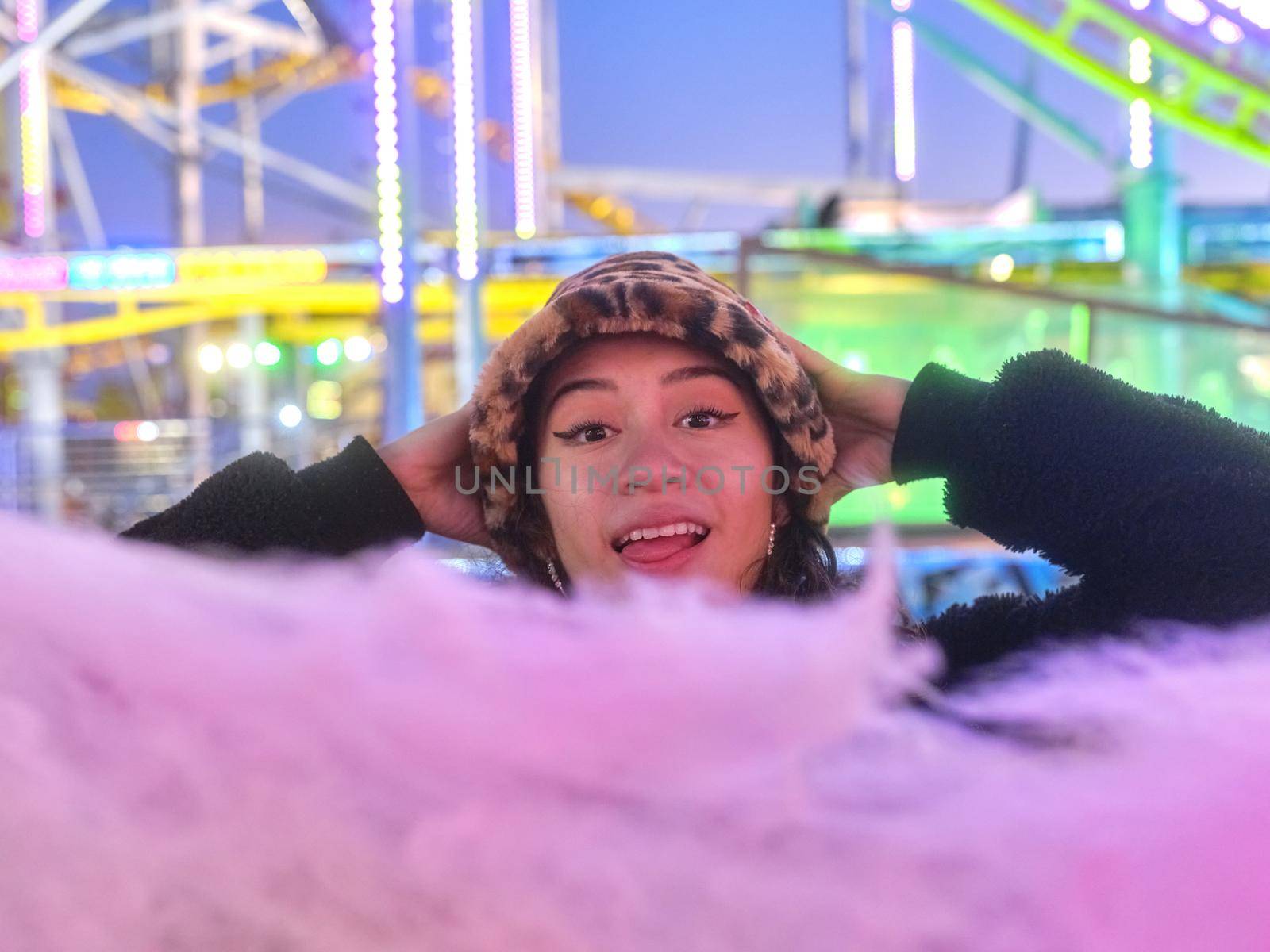 Surprised woman in front of a cotton candy ball at an evening fair by WesternExoticStockers