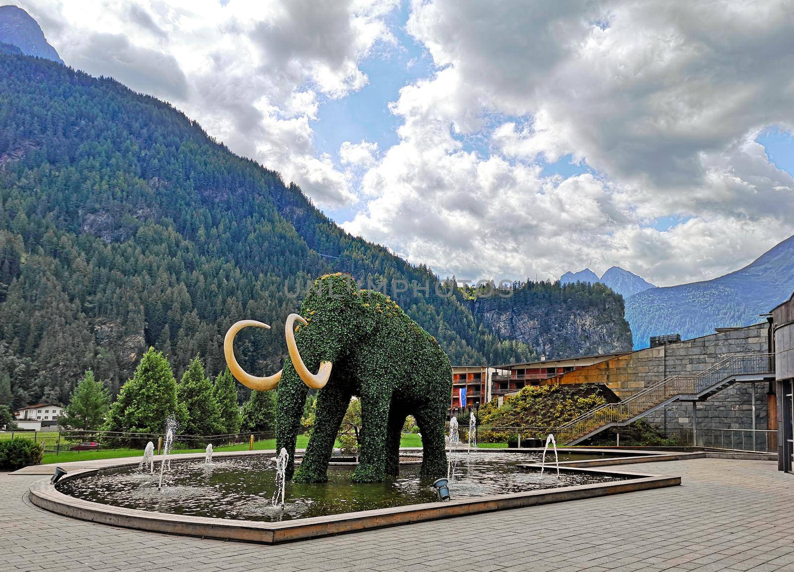 urban and naturalistic landscape in Austria in the town of Wattens, fountain with an elephant-shaped hedge in the center