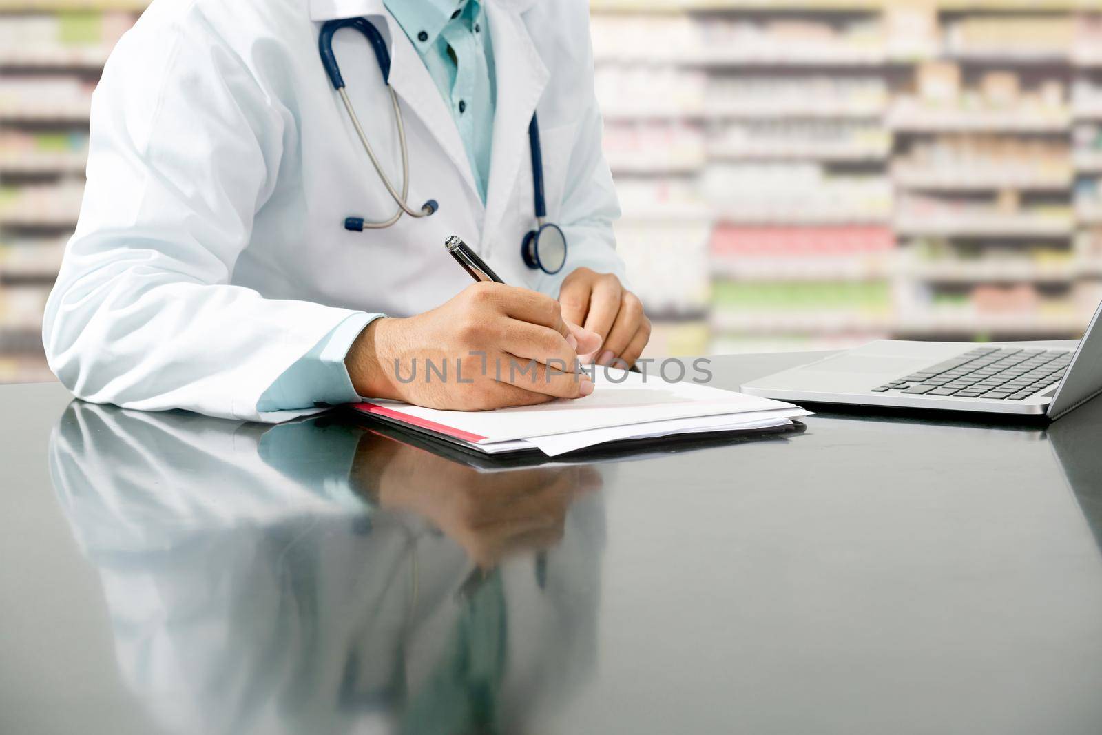 Pharmacist writes on documents at pharmacy. by biancoblue
