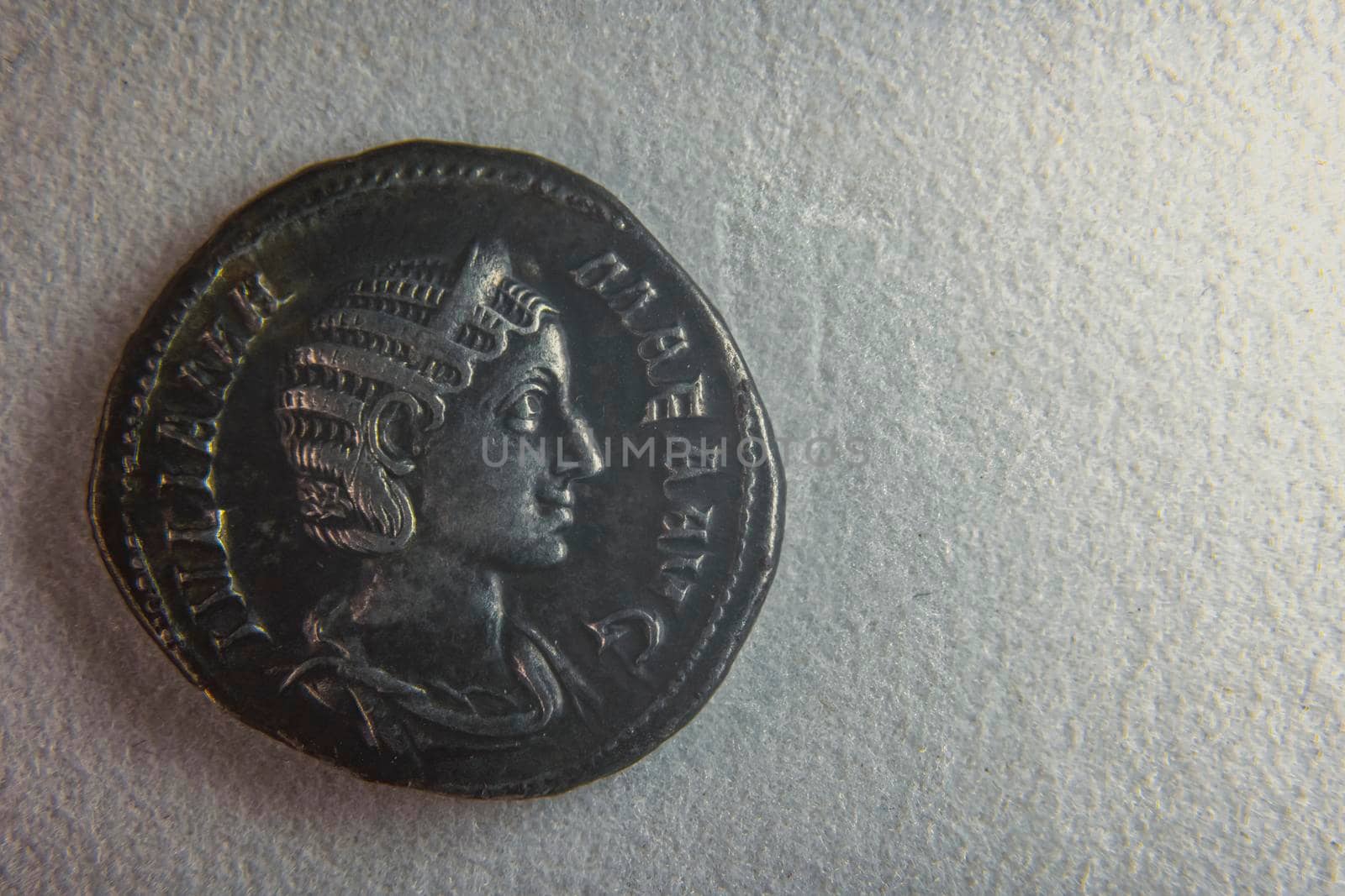 old roman coin on white paper closeup