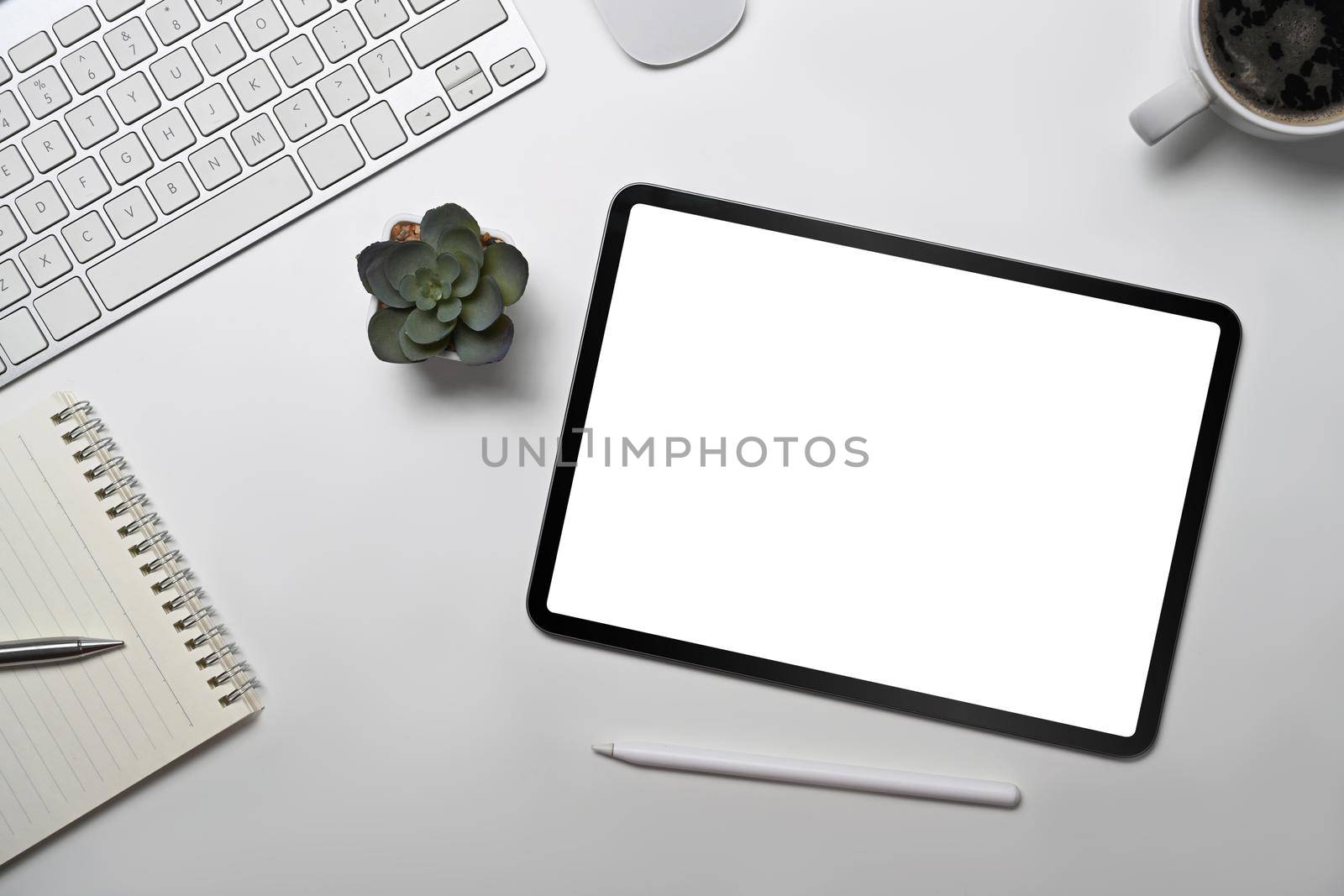 Top view digital tablet, notebook, coffee cup and succulent plant on white office desk by prathanchorruangsak