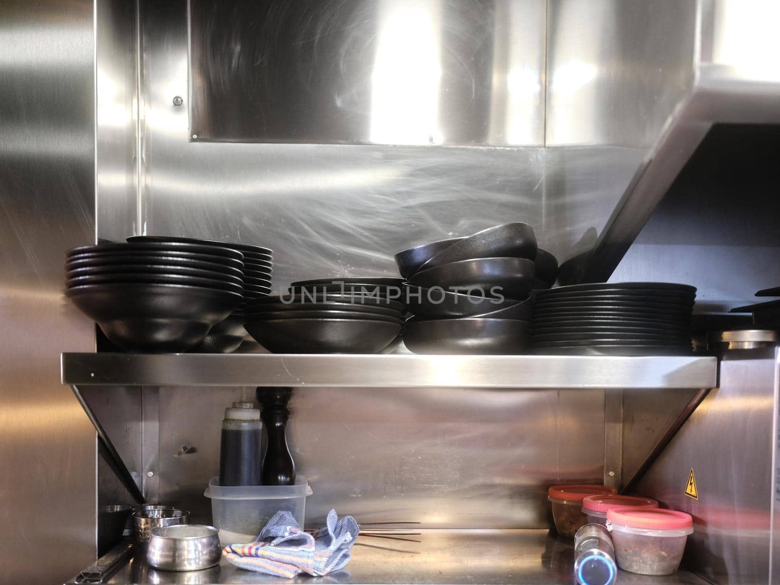 Restaurant with metal shelving with stacked dishes ready for kitchen service by WesternExoticStockers