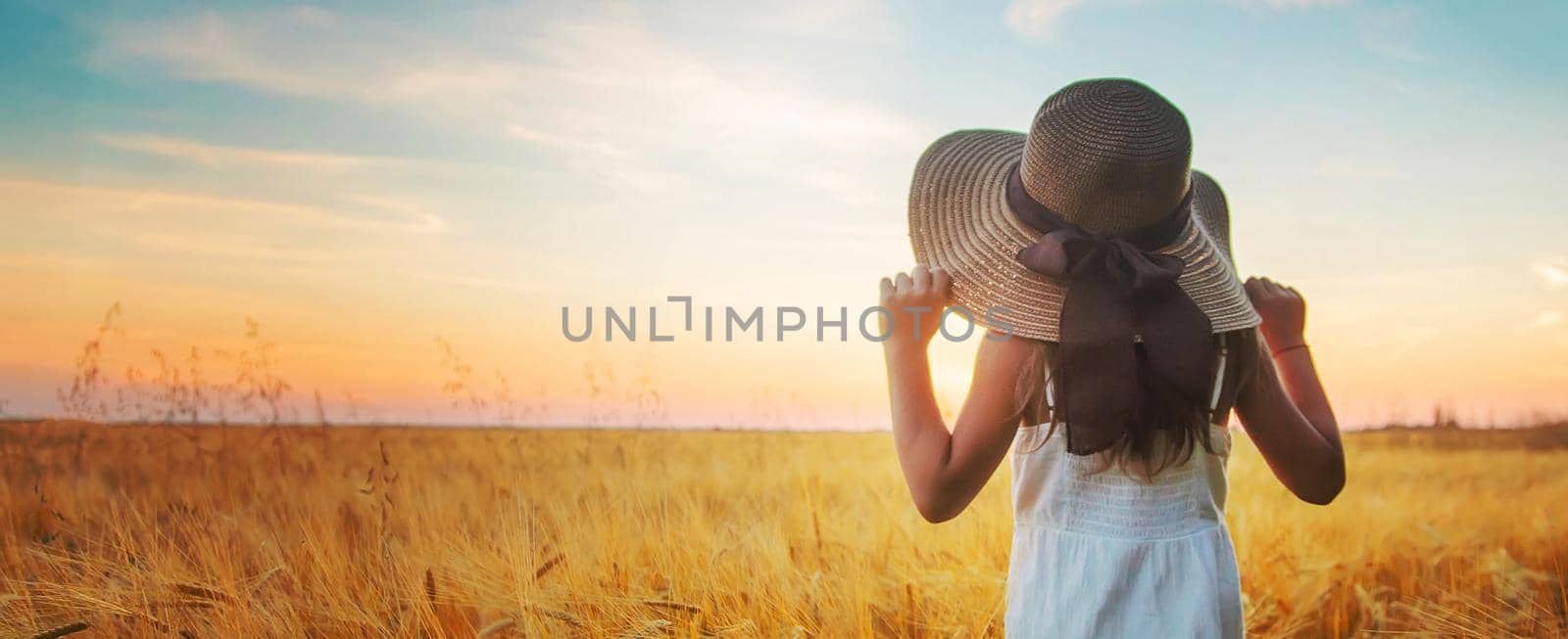 A child in a wheat field. Sunset. Selective focus. nature.