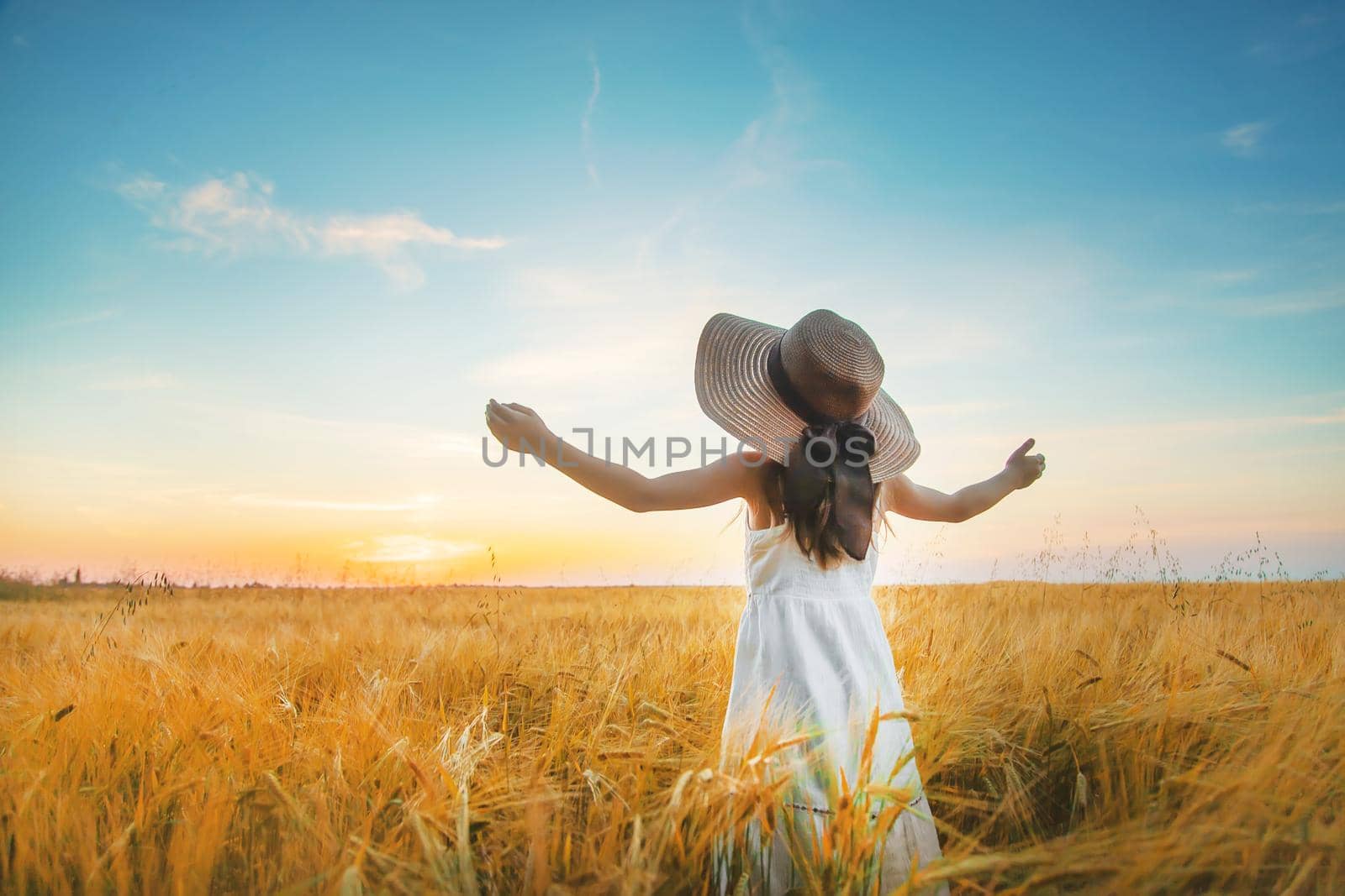 A child in a wheat field. Sunset. Selective focus. by yanadjana