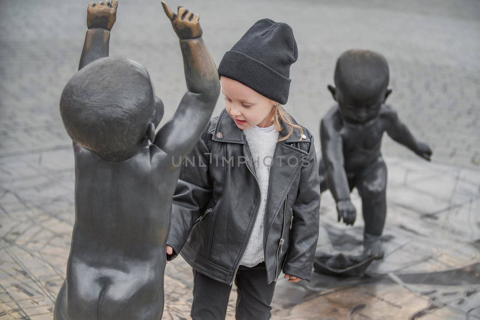 little girl is playing in the city square