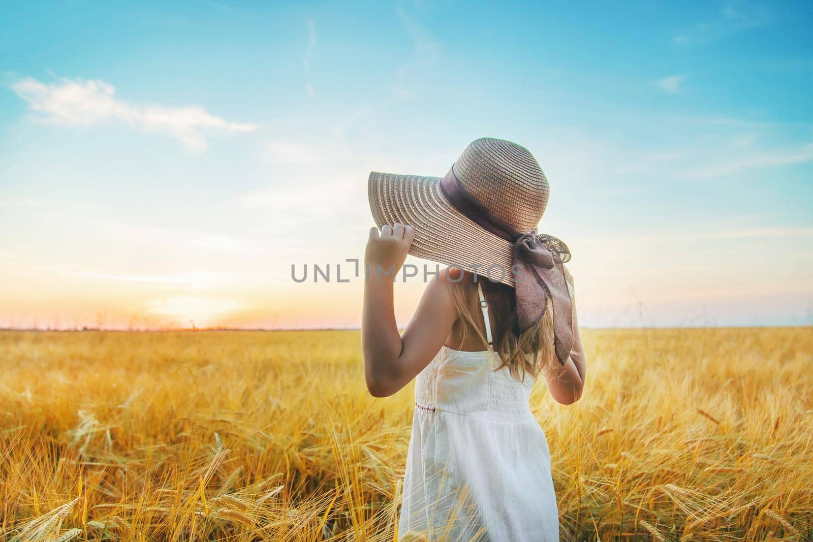 A child in a wheat field. Sunset. Selective focus. by yanadjana