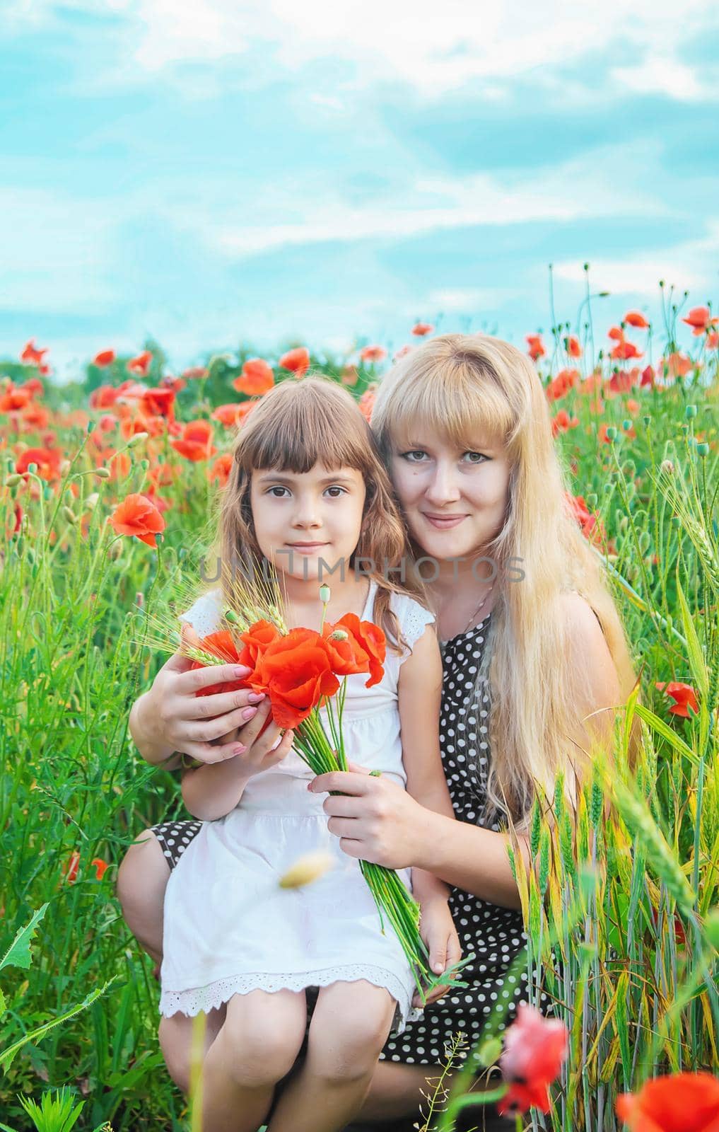 children girl in a field with poppies. selective focus. by yanadjana