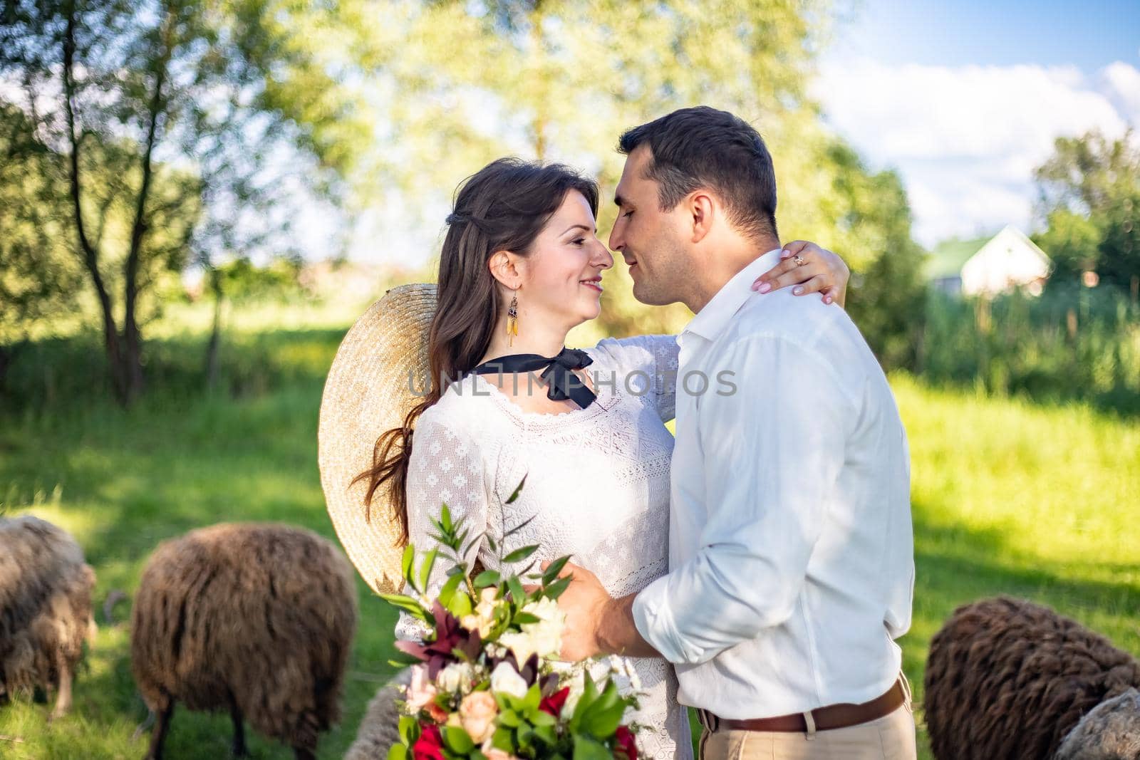 a wedding couple of lovers, the bride and groom, are standing in the middle of beautiful green hills by Anyatachka