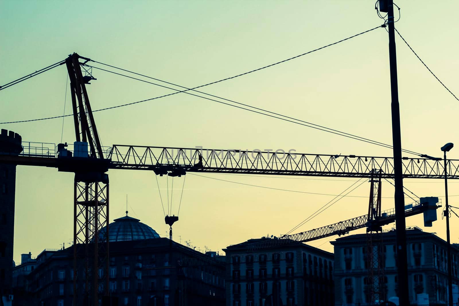 Industrial cranes in the center of Naples photographed during sunset