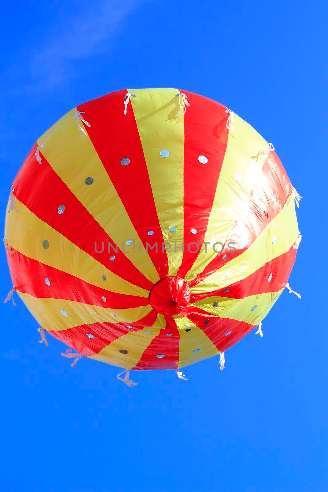 A striped balloon flies in the sky.