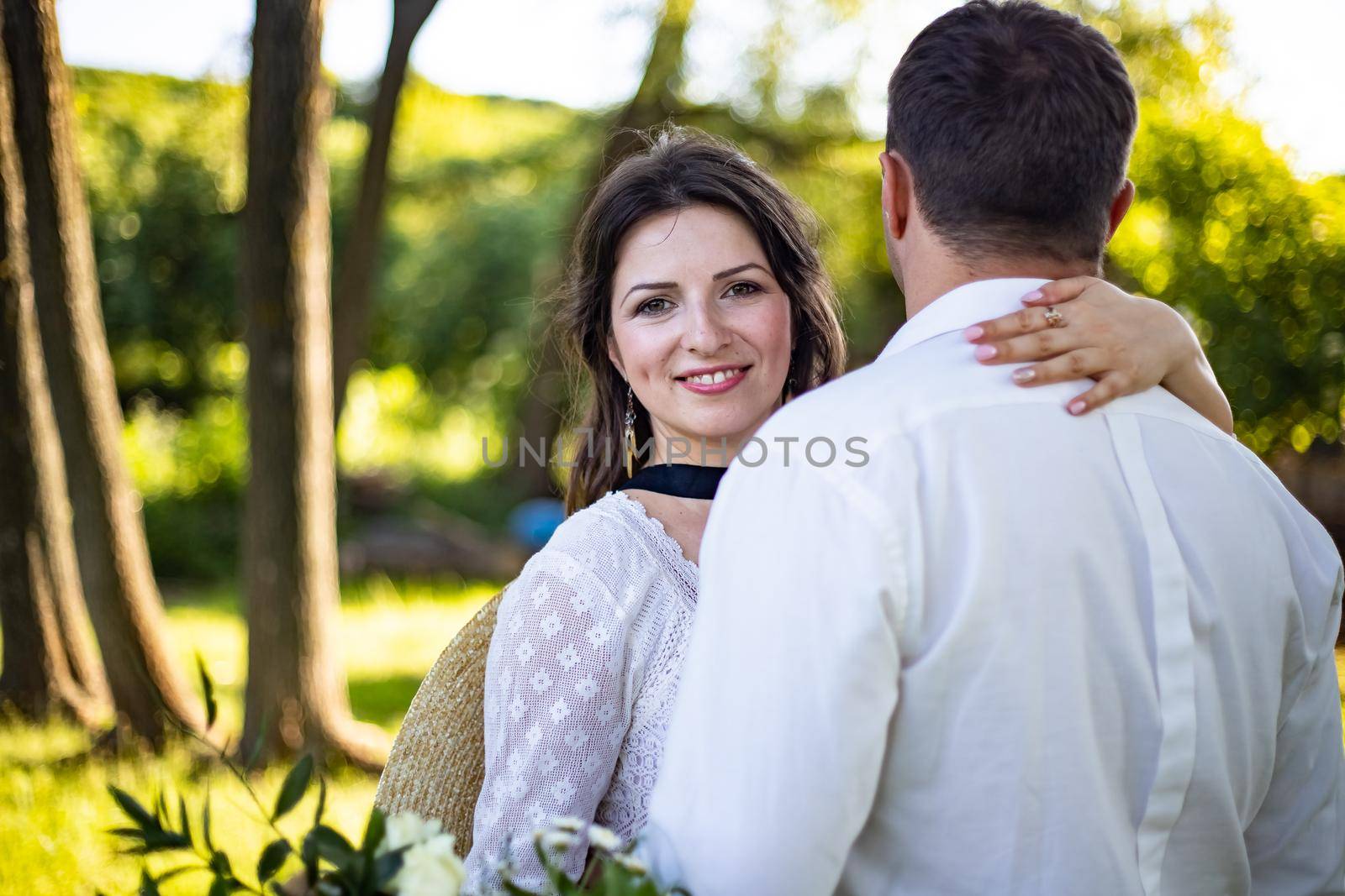 Portrait of a happy bride and groom, in boho style wedding dresses, against the backdrop of beautiful nature.