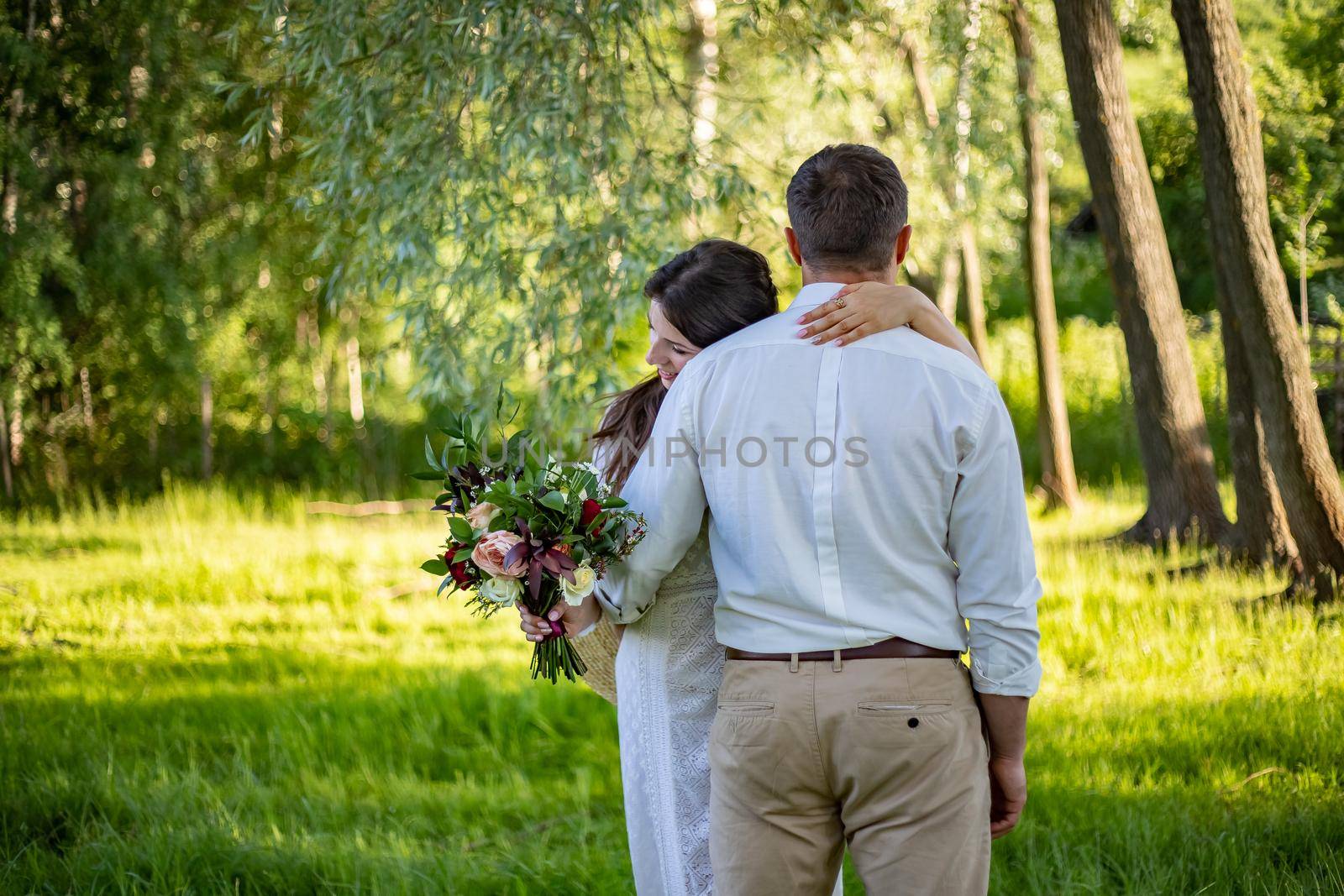 Portrait of a happy bride and groom, in boho style wedding dresses, against the backdrop of beautiful nature. by Anyatachka