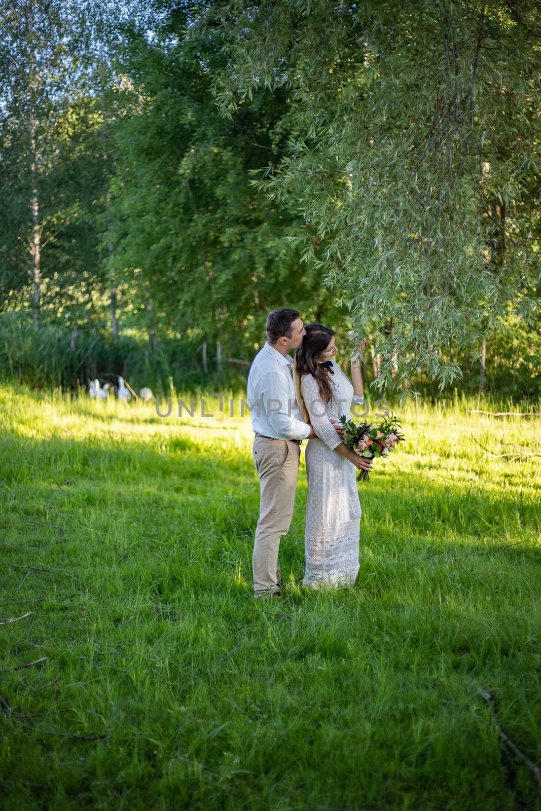 Elegant bride and groom posing together outdoors on a wedding day by Anyatachka