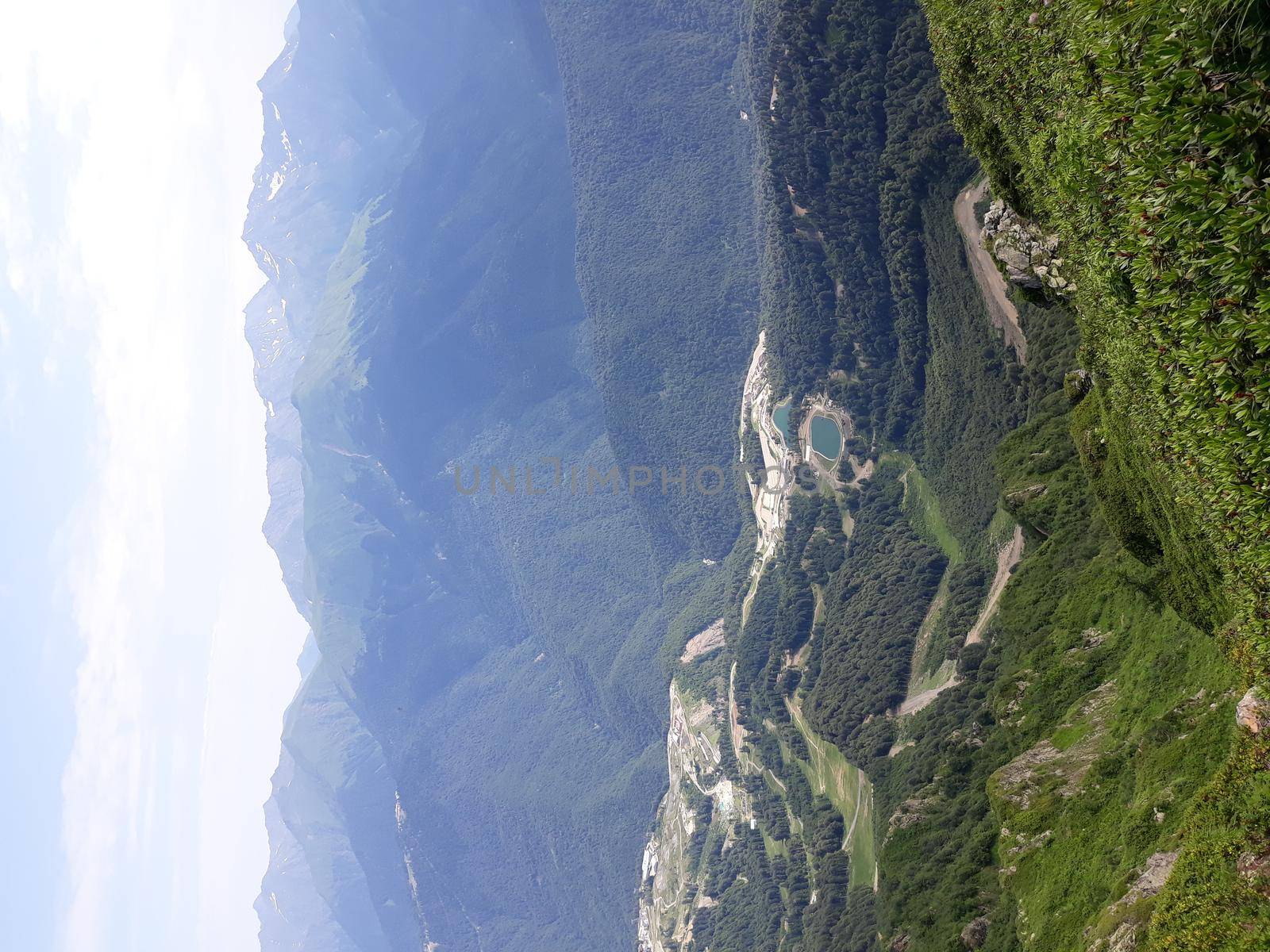 Panoramic mountain landscape with valleys and forested mountain peaks.