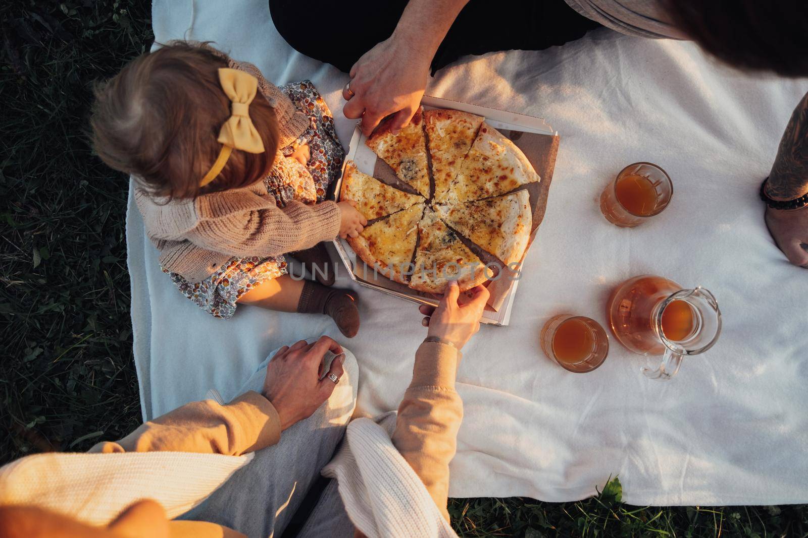 Top Down View Young Family Mom Dad and Baby Daughter Enjoying Picnic Outdoors and Eating Pizza