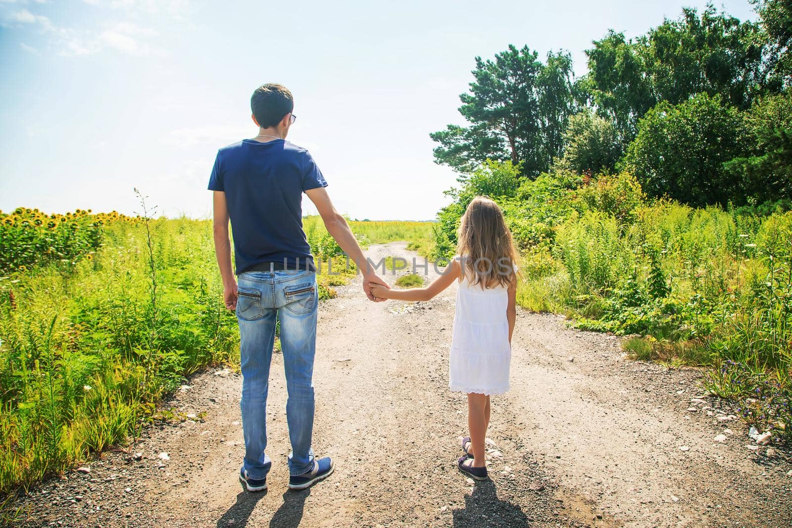 Father and daughter walk holding hands. Selective focus. by yanadjana