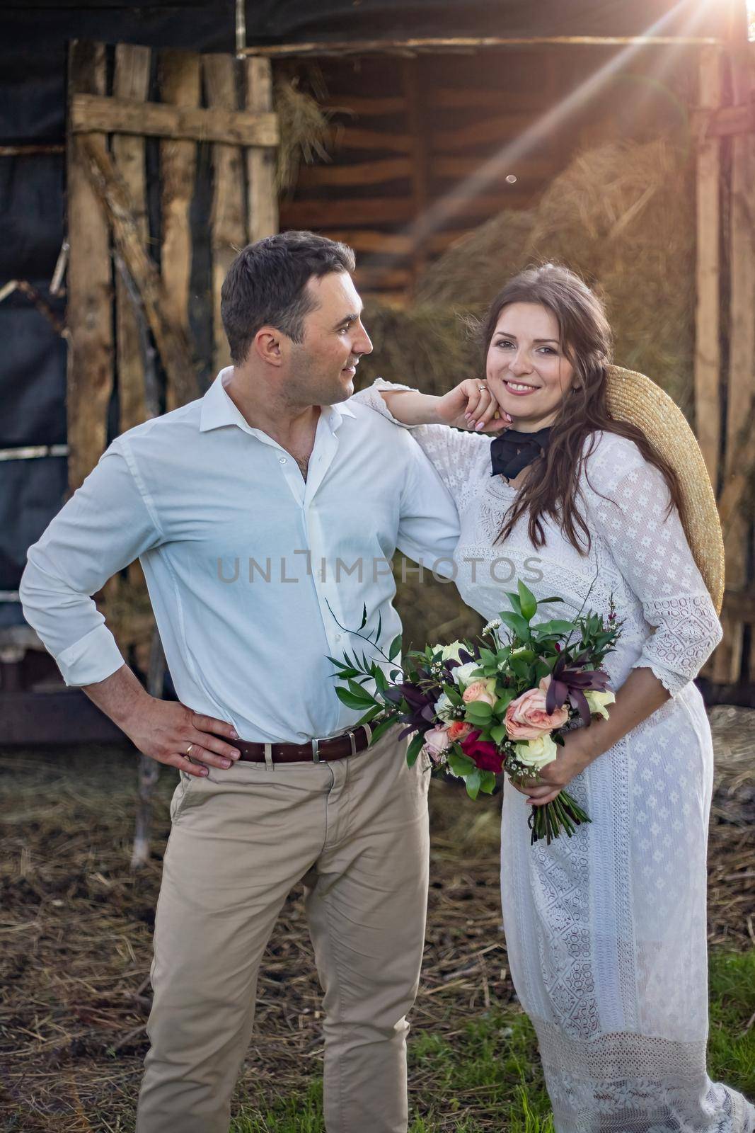 bride in cowboy style sits on threshold of hayloft