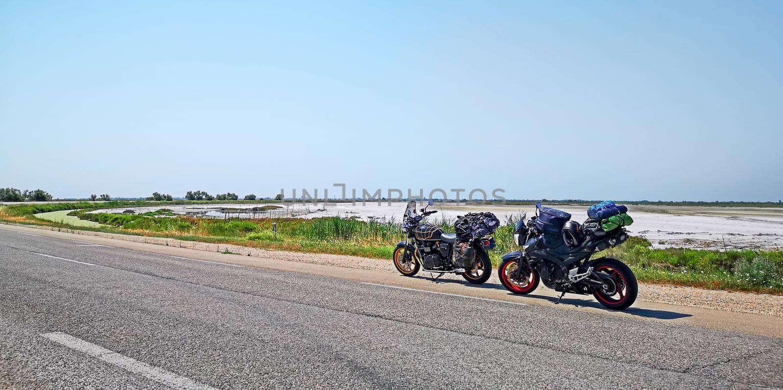 motorcycles parked on the side of the road during a trip to Camargue near Lake Sale