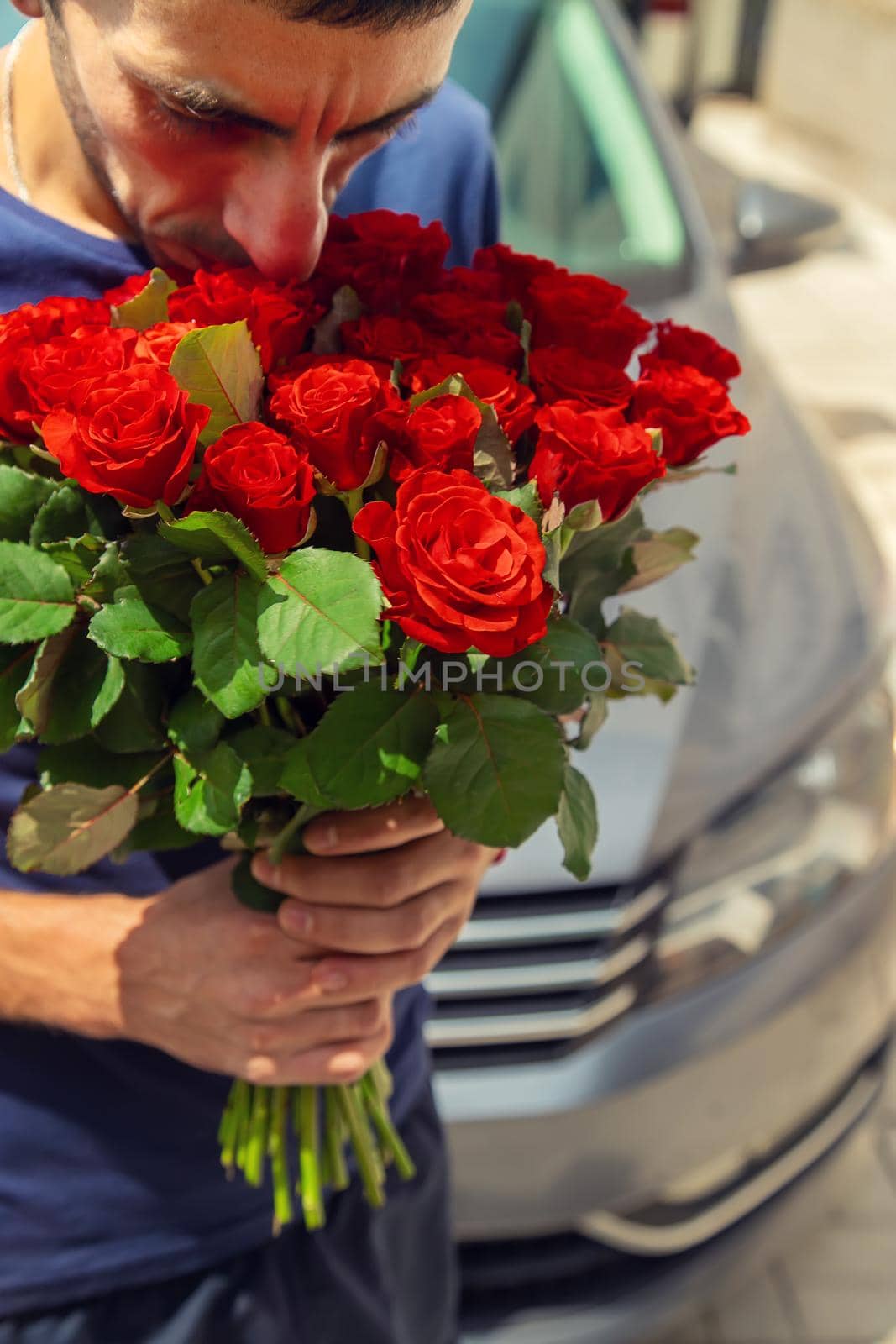 A bouquet of red roses in the hands of a man. Selective focus. Holiday.