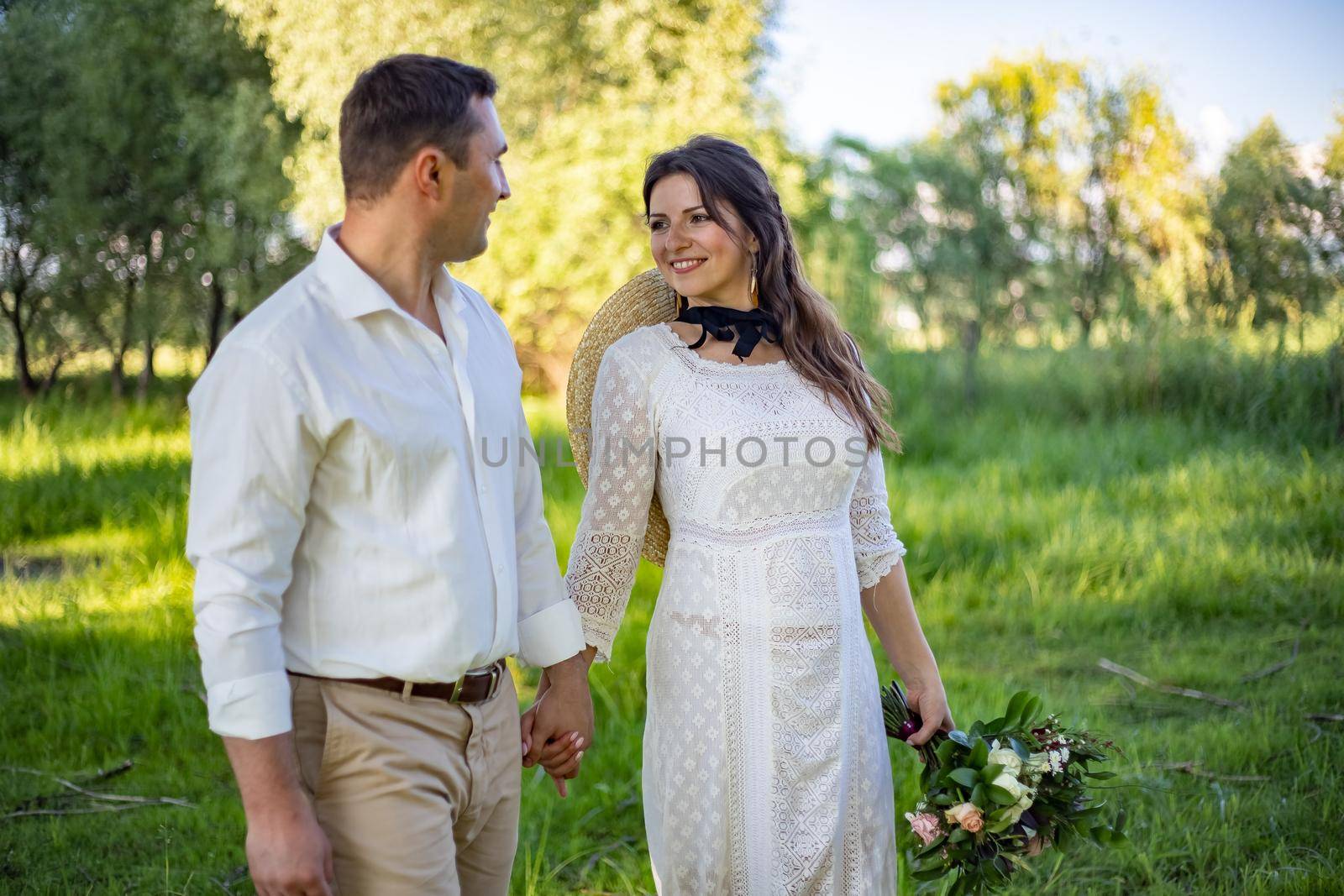 Wedding in the castle. Stylish and beautiful. Princess's dress. Lush white dress and veil. Bride is a brunette. The groom in a black suit. A couple is walking in the park on the castle grounds. by Anyatachka