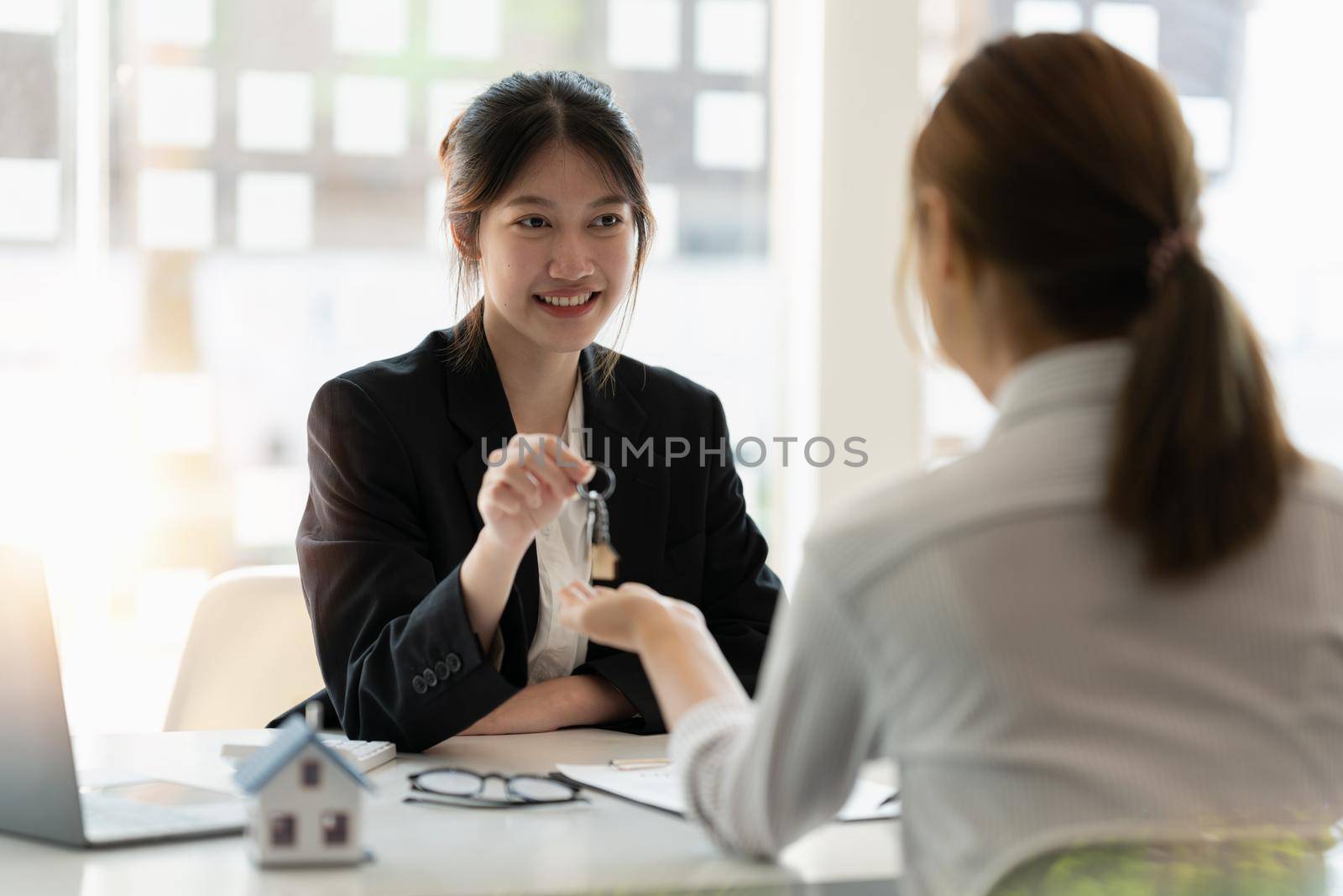 Real estate broker and customer shaking hands after signing a contract: real estate, home loan and insurance concept by nateemee