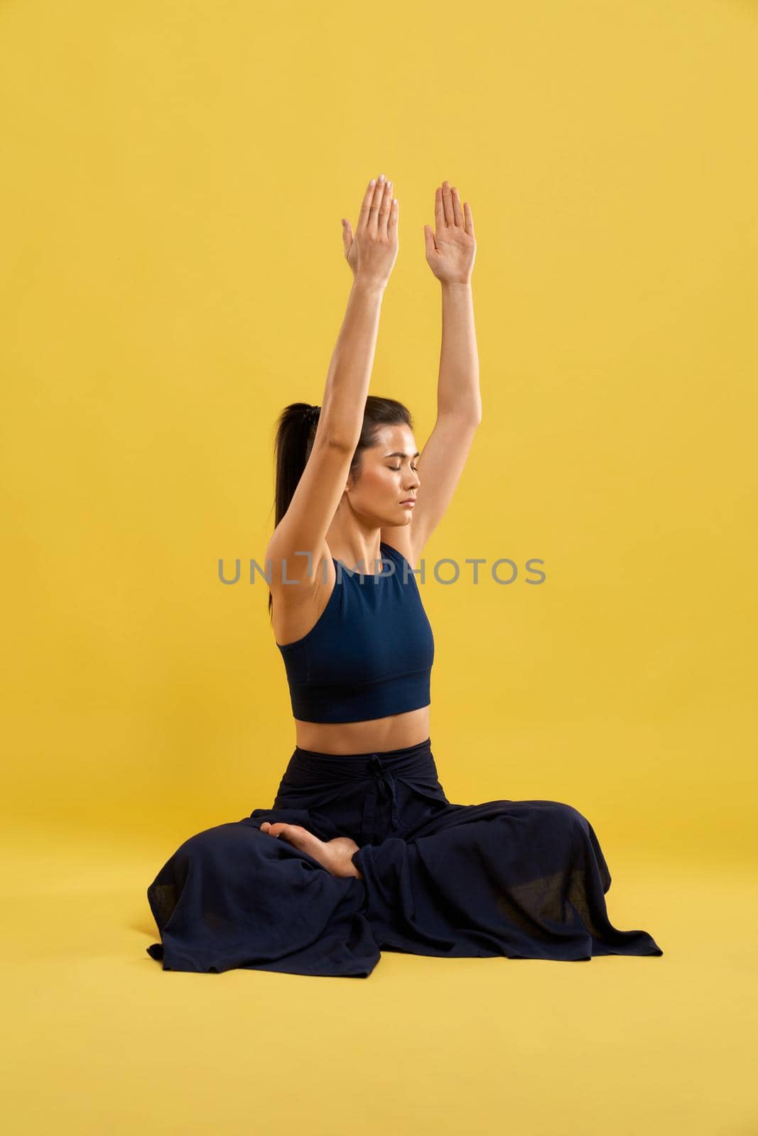 Woman training yoga pose with gazed up hands indoors. by SerhiiBobyk
