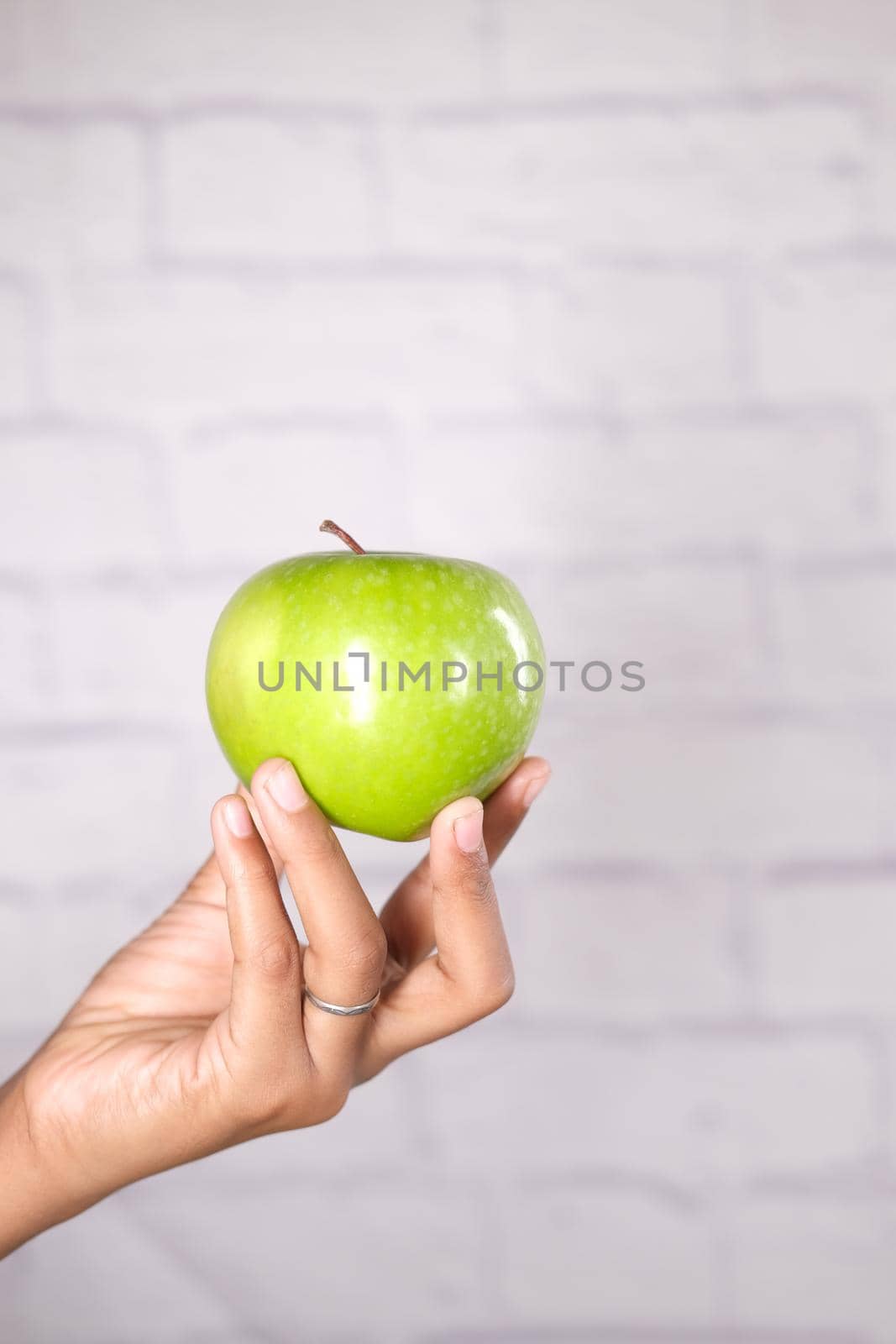 child boy hand hold a apple on blue background .