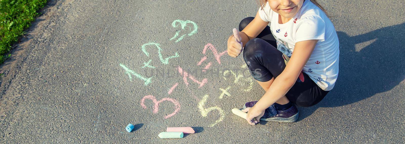 The child decides grunts on the asphalt. Selective focus. by yanadjana